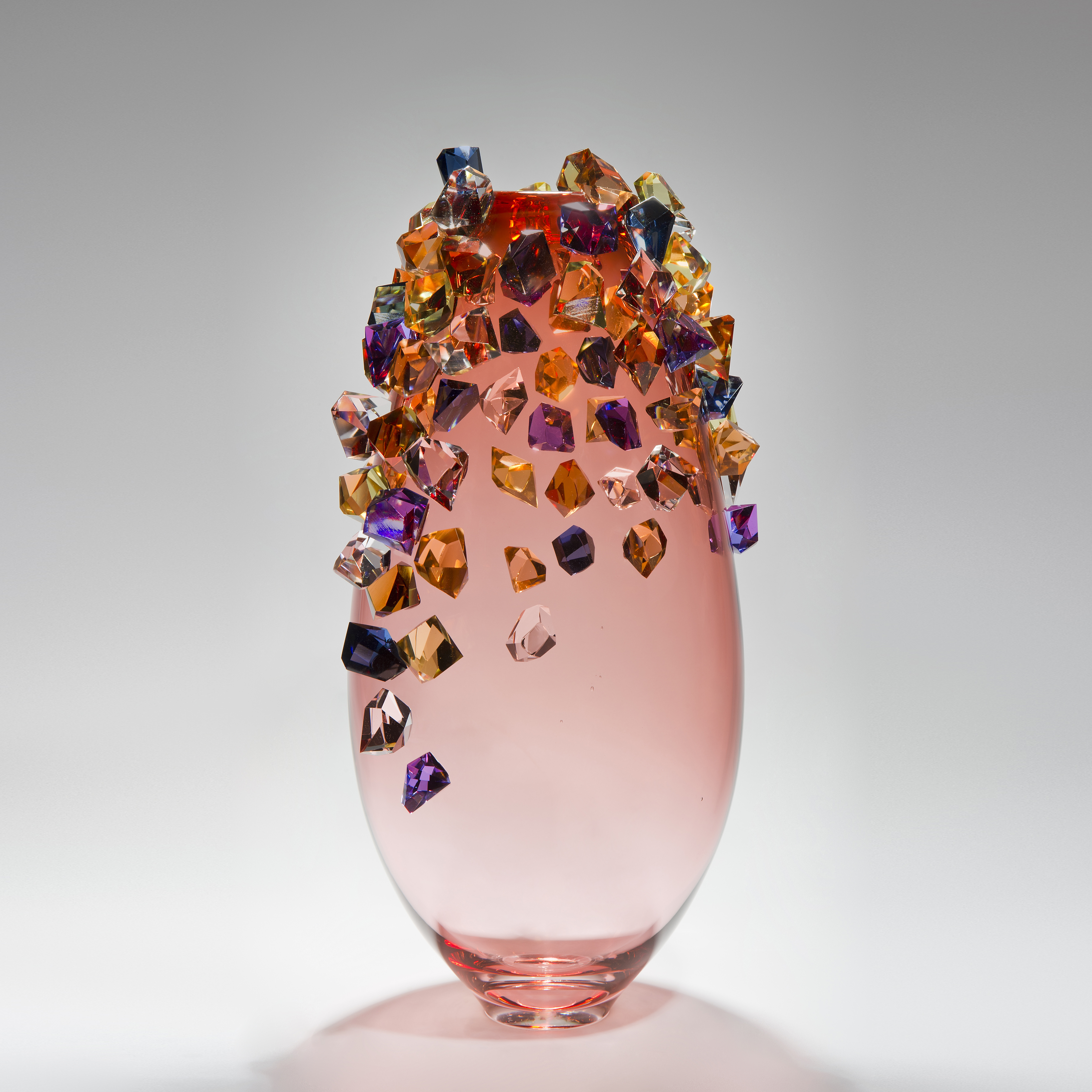pink sculpted glass vase with colored crystals adorning the outer edges