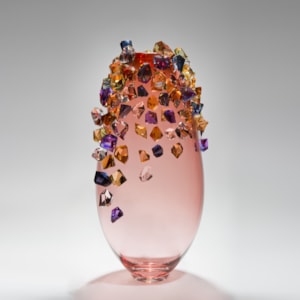 pink sculpted glass vase with colored crystals adorning the outer edges
