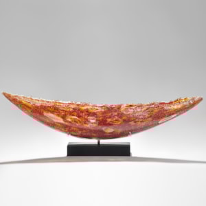 solid glass art sculpture in concave shape with detailled patterns in red and yellow