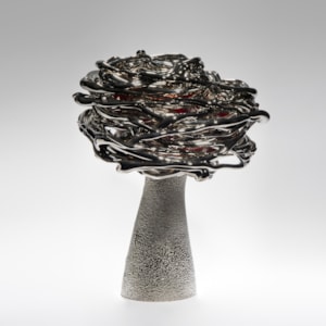 black red and platinum art-glass sculpture from blown glass of flower in wind