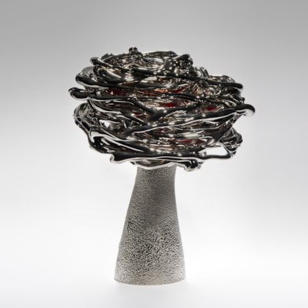 black red and platinum art-glass sculpture from blown glass of flower in wind