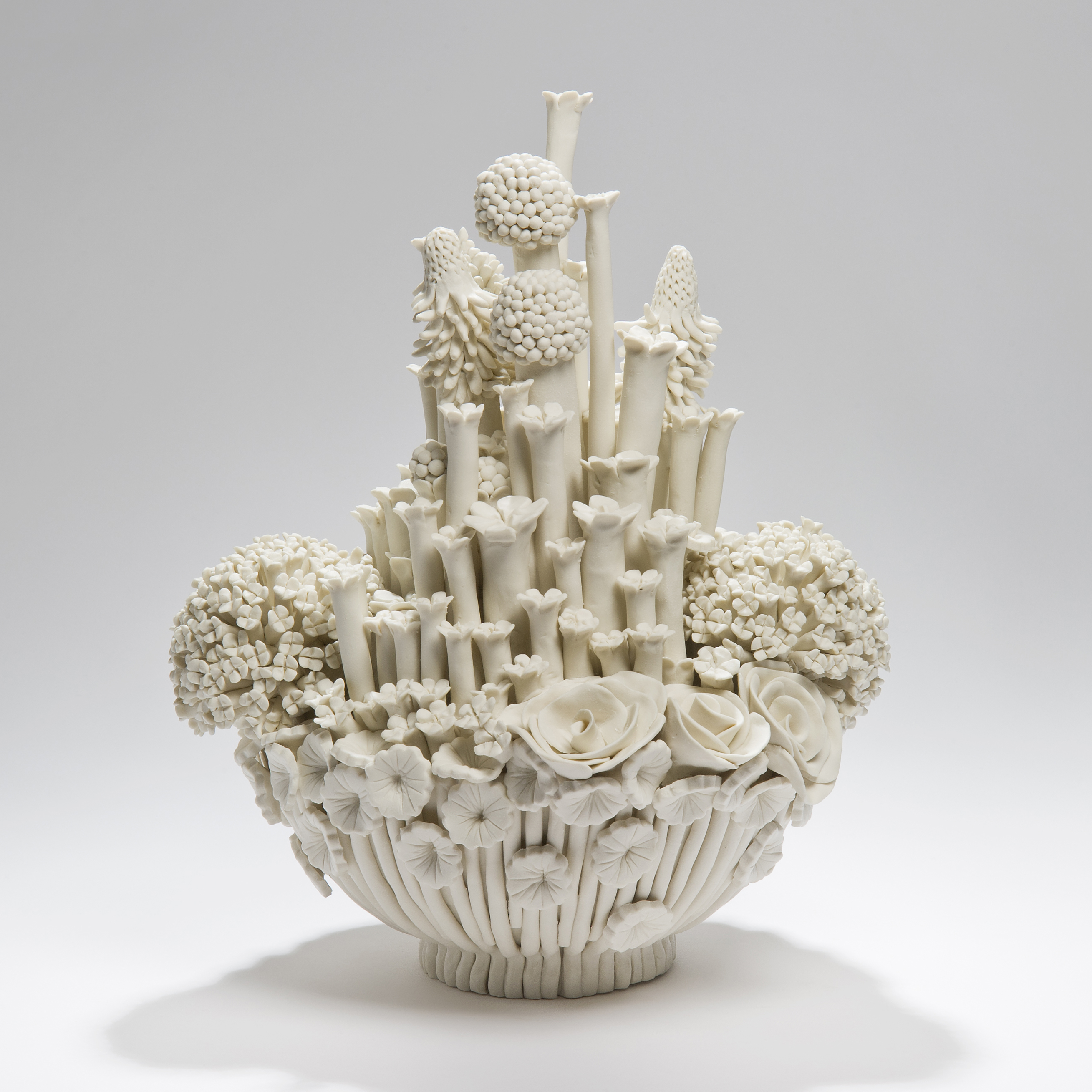 white porcelain sculpted artwork of roses sprouts and flowers