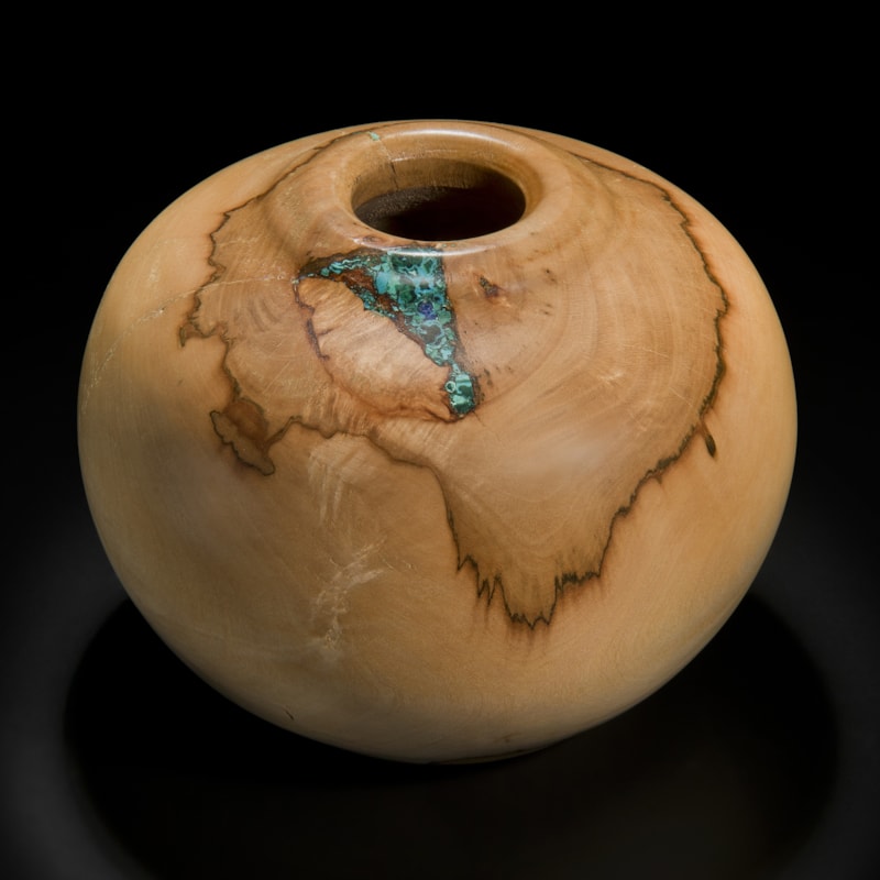 sculpture of vessel made from sycamore in creamy brown inlaid with precious minerals