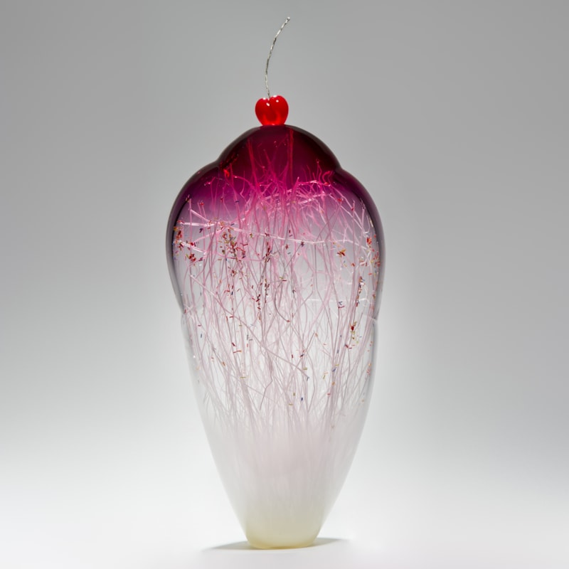 tall and thin decorative glass ornament in white and pink with natural looking internal structure and cherry on top