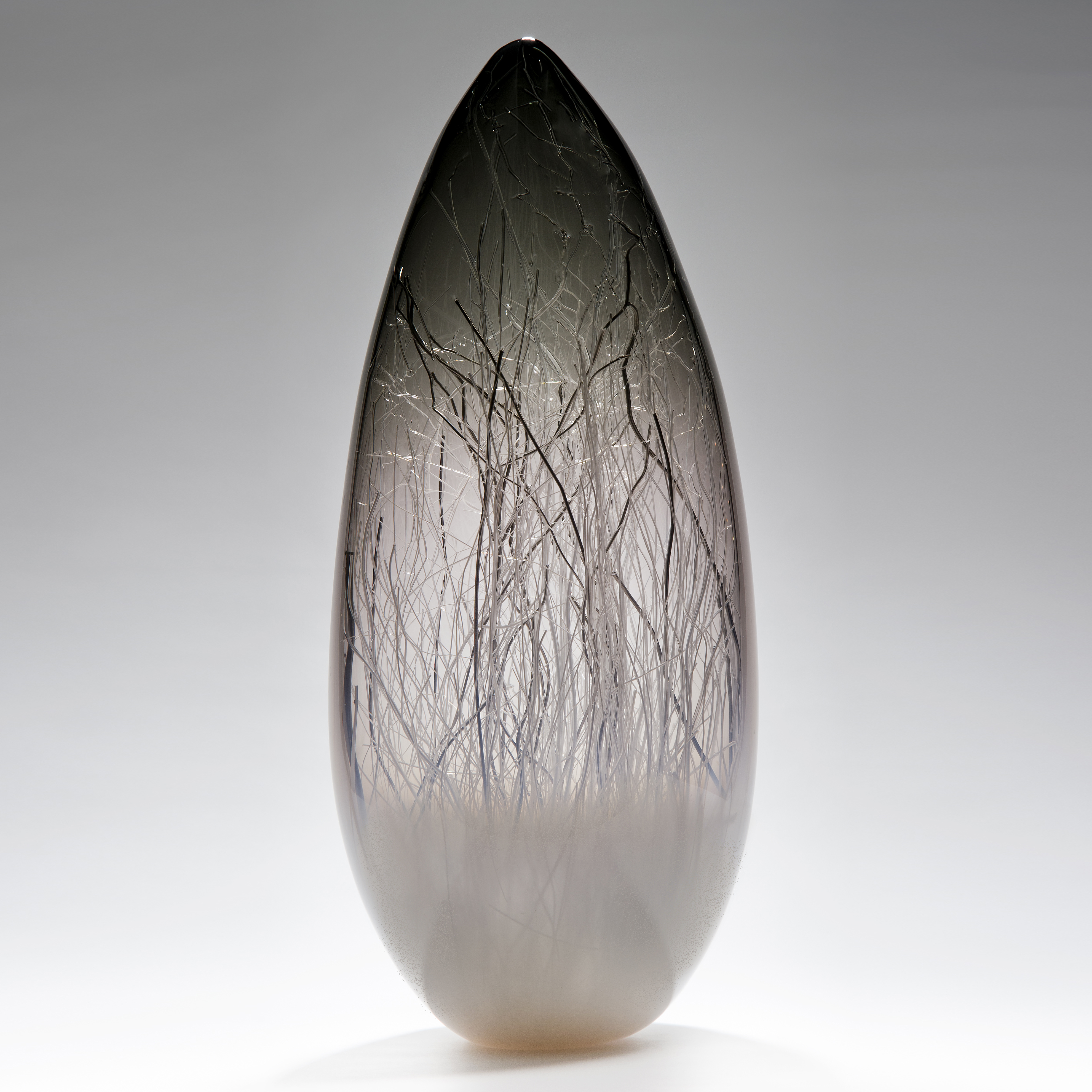 sculpted glass vessel in grey with wire interior resembling winter forest