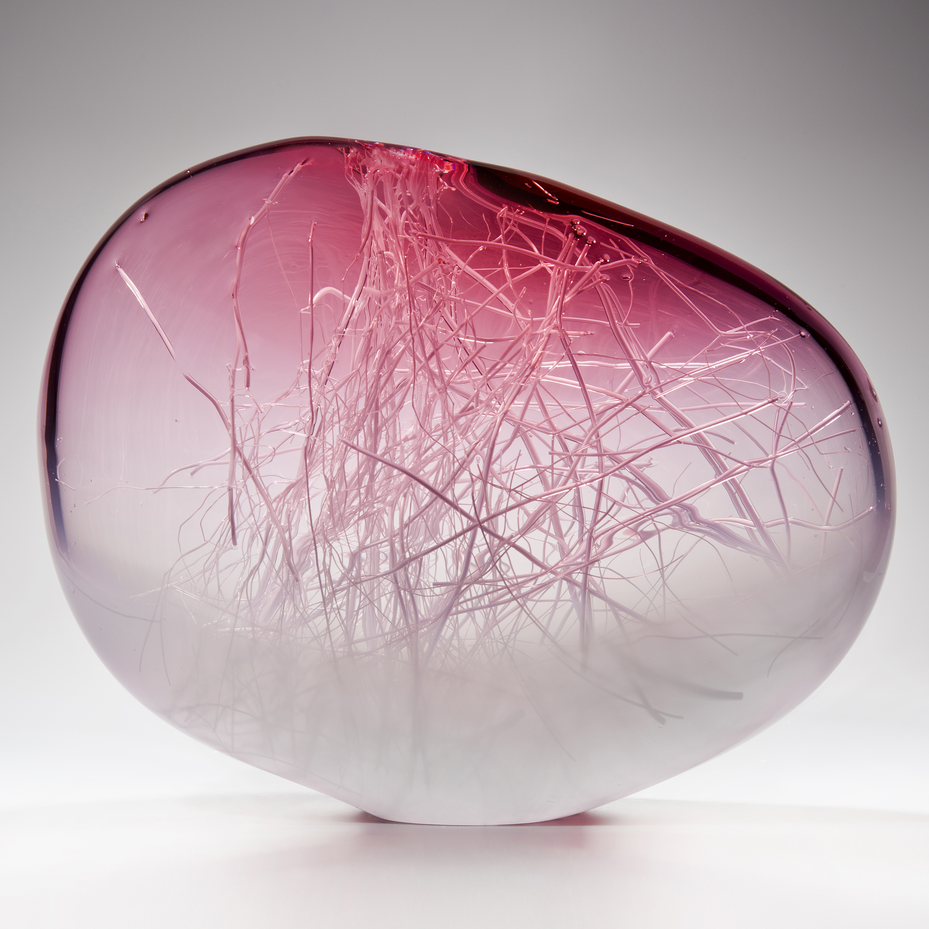 orb shaped art glass sculpture in pink and white with internal wire structure