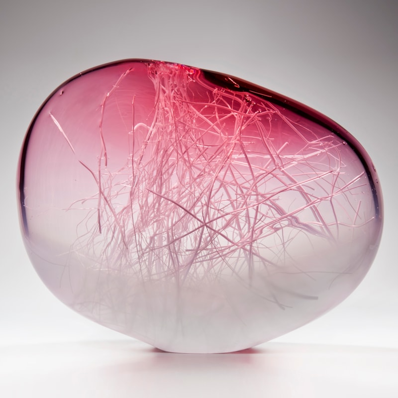 orb shaped art glass sculpture in pink and white with internal wire structure