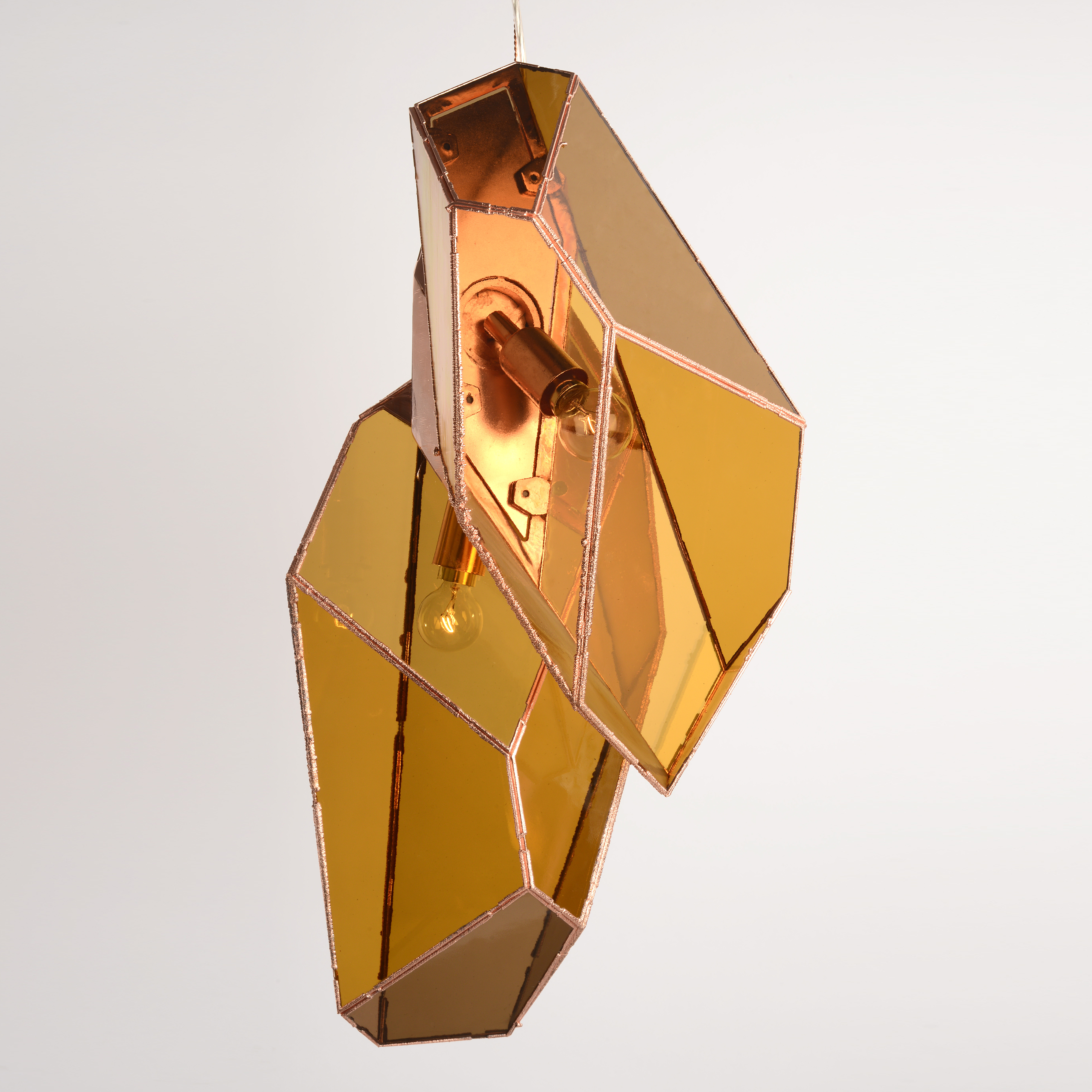 two hanging pendant lights from glass and copper in amber