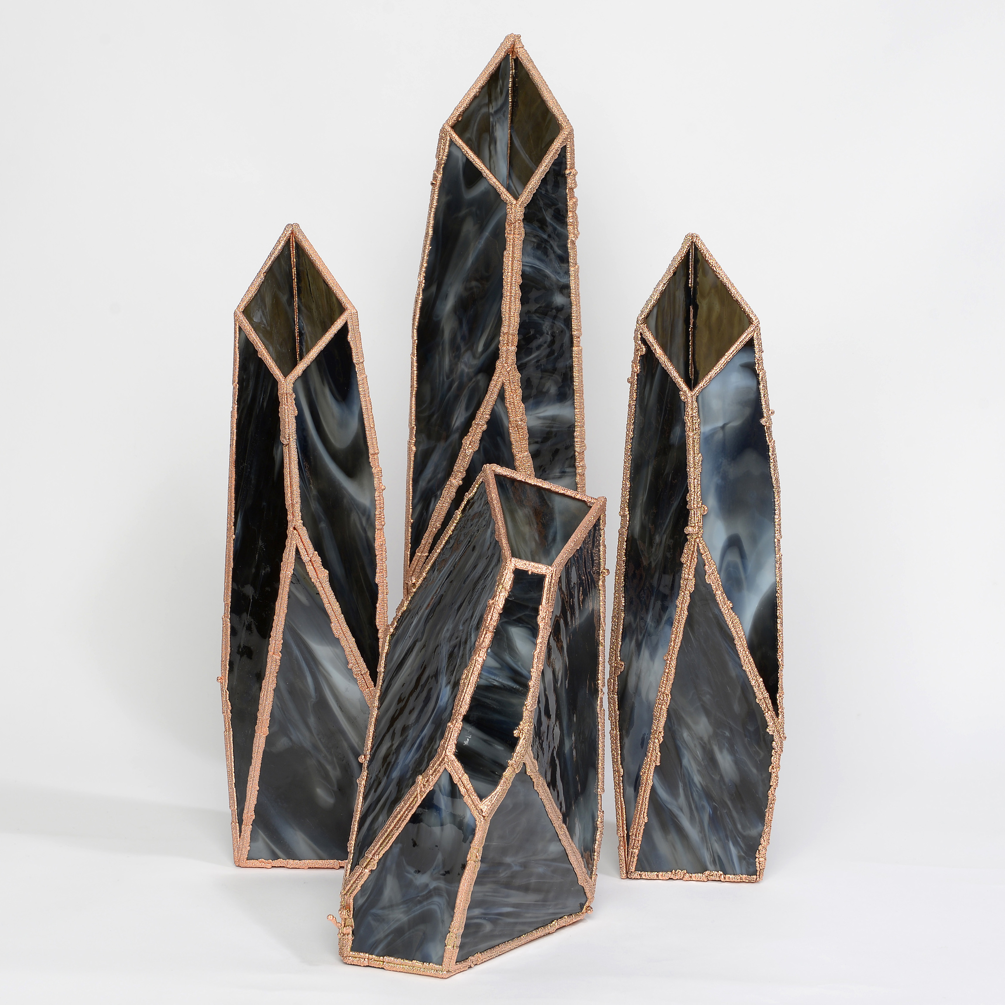 four crystal shaped vases in marbled black with copper frames