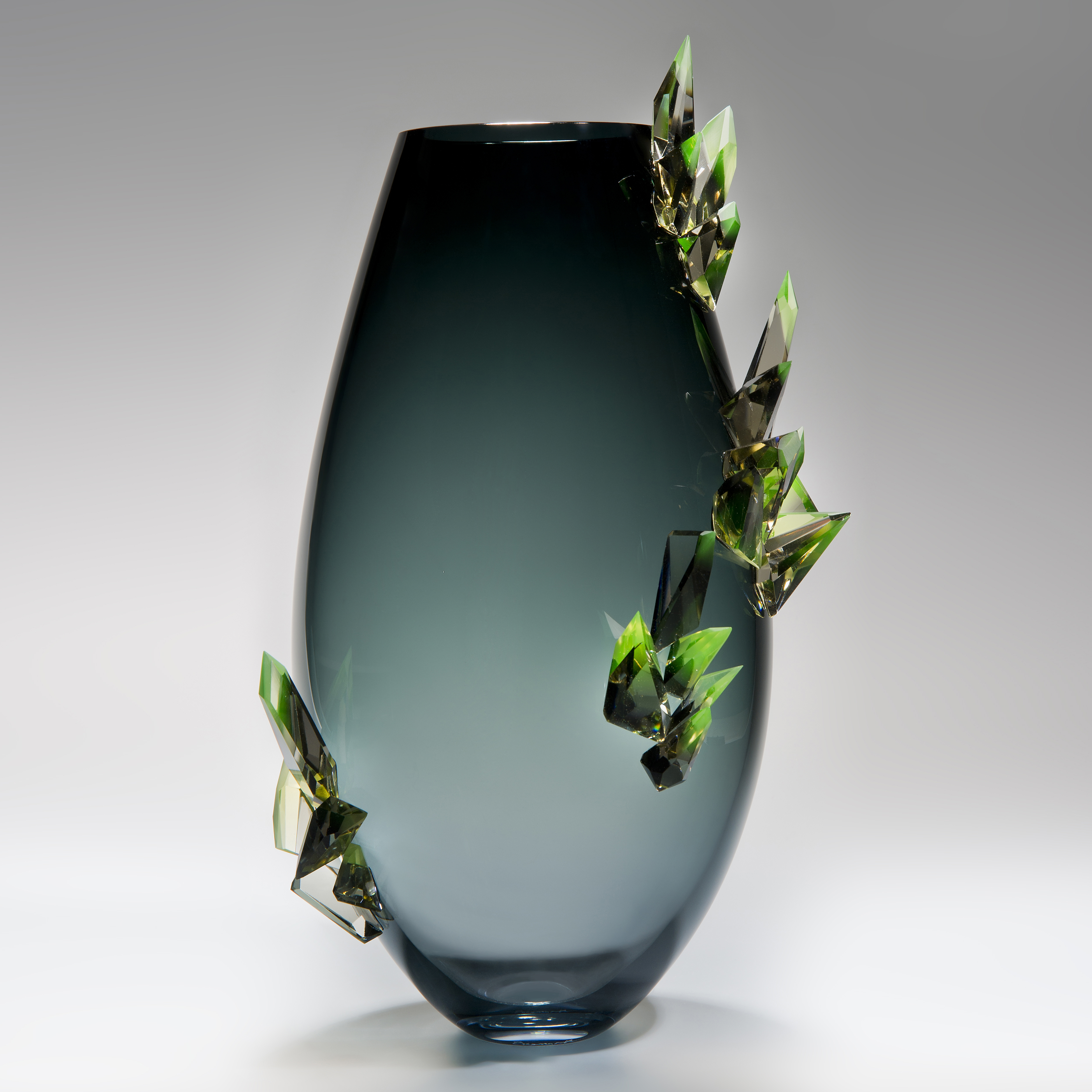 minimalist glass vase sculpture in light to dark turquoise with green external crystals
