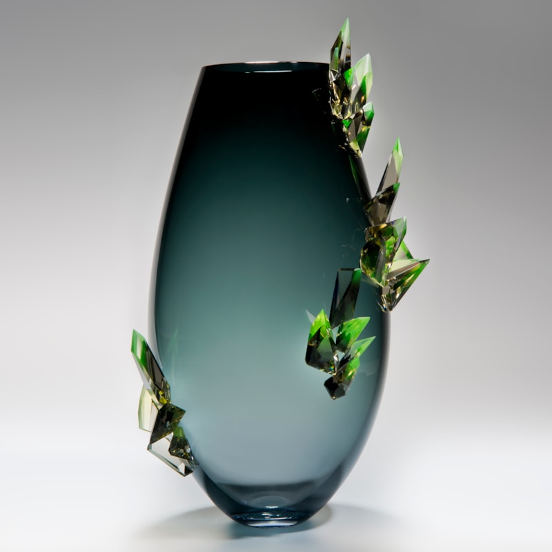 minimalist glass vase sculpture in light to dark turquoise with green external crystals