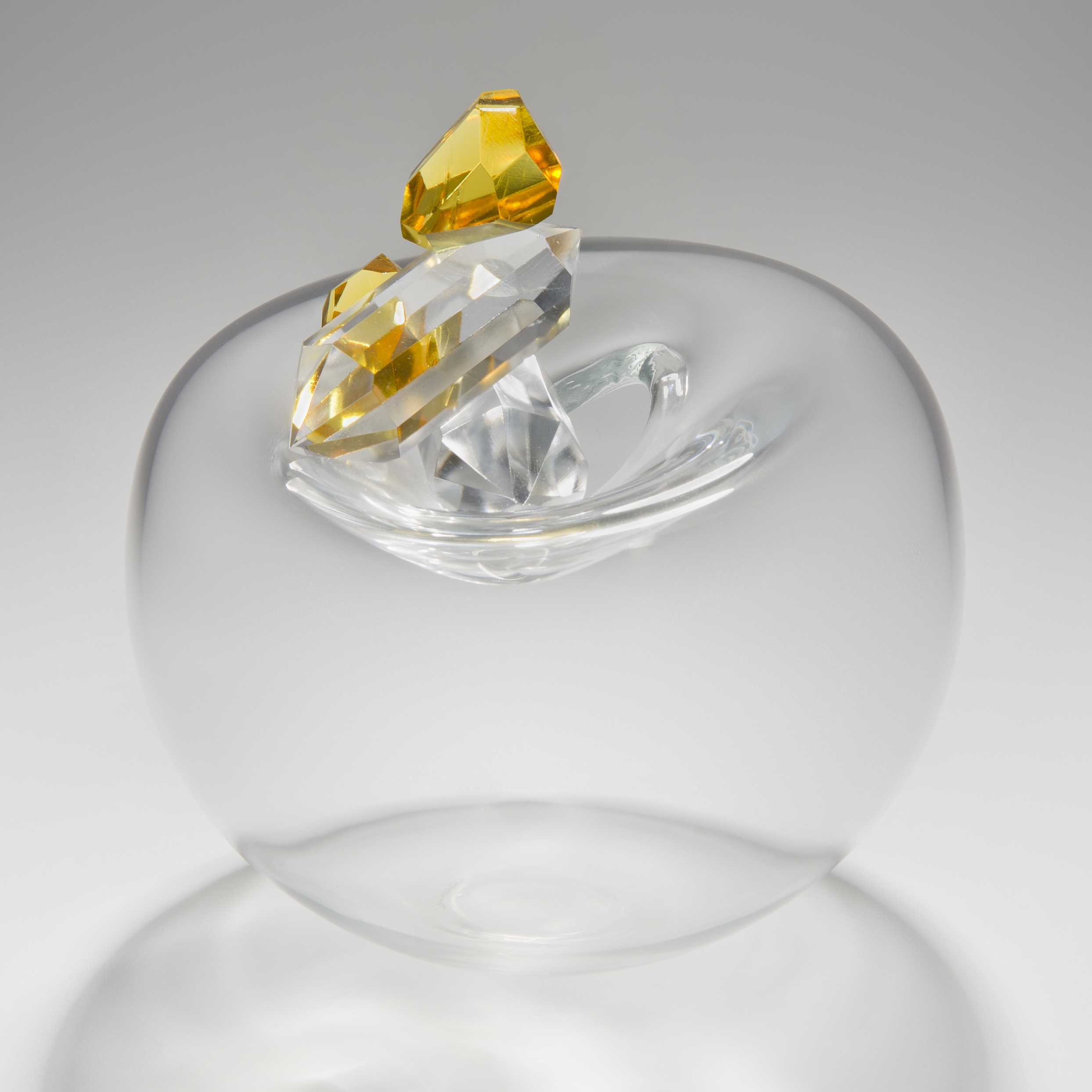 blown glass vase in black in the shape of an apple with red white and gold crystal additions