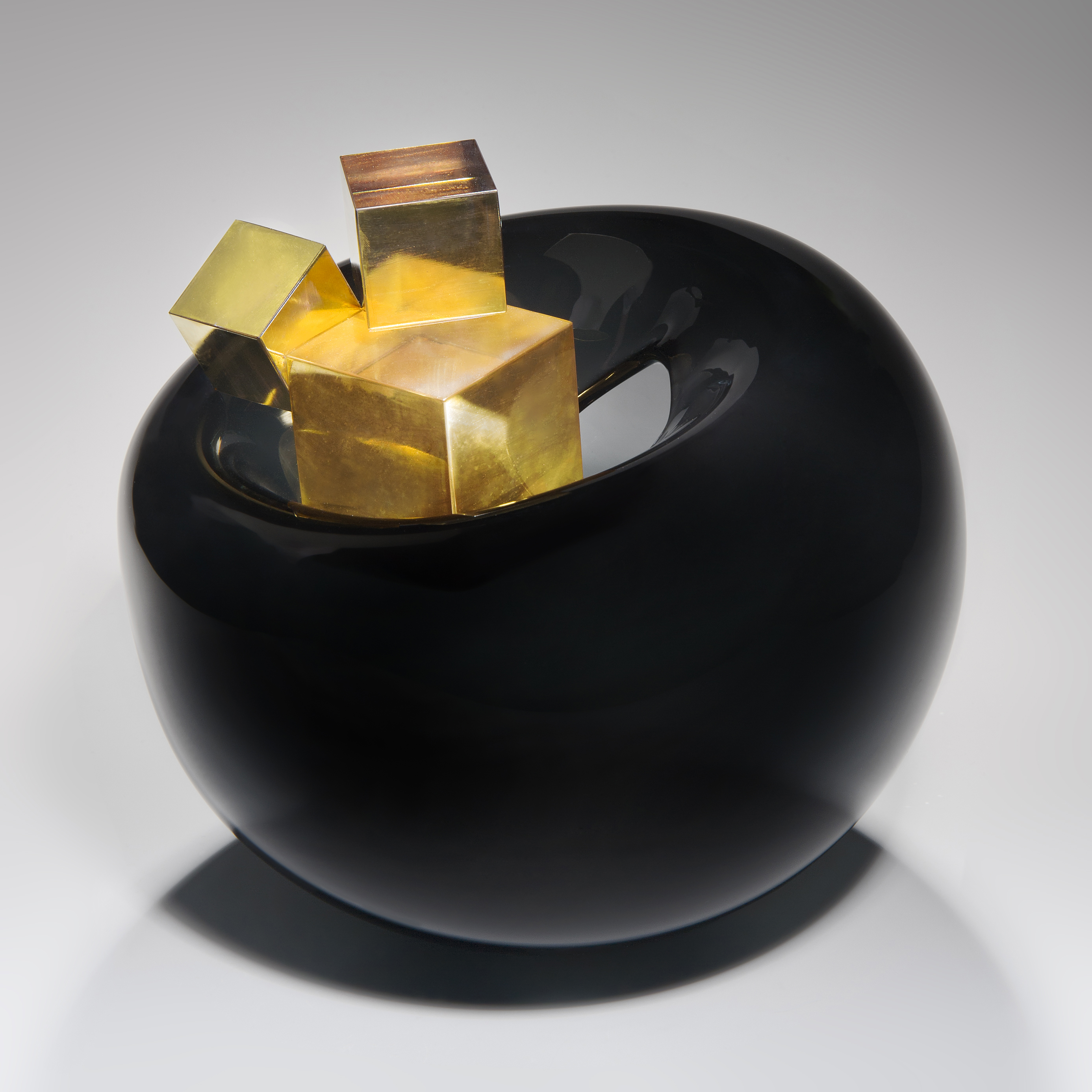 black modern rounded art glass sculpture with gold glass cubes in centre