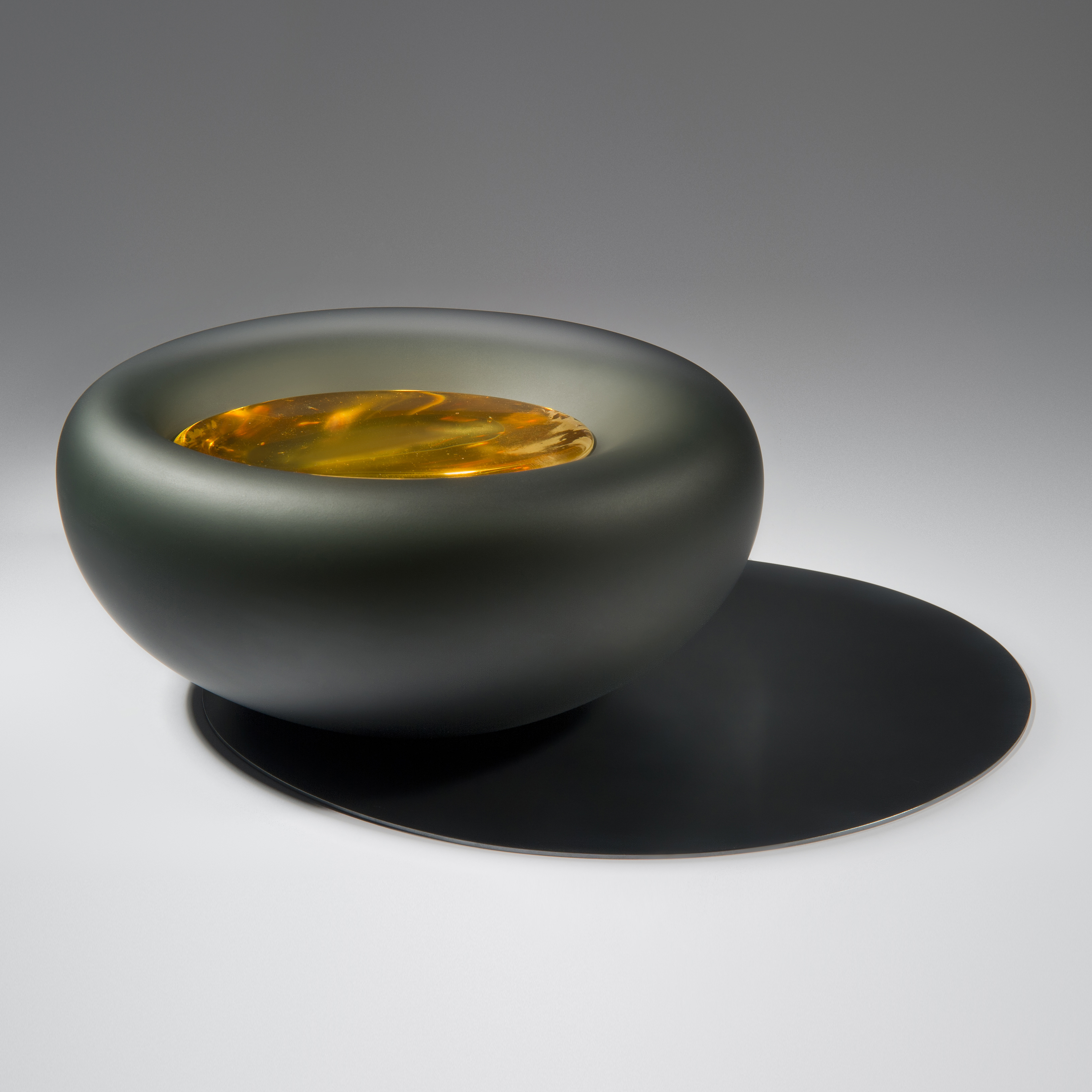 grey bowl glass and metal ornament with fiery yellow liquid like texture inside