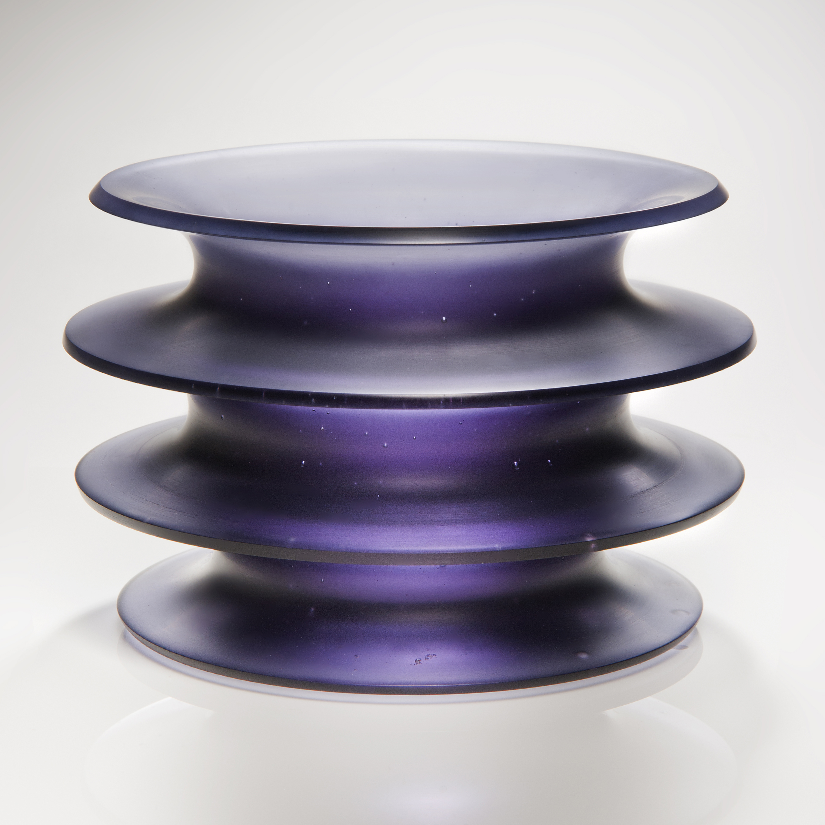 purple glass sculpture with four protruding rings