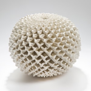 a round ceramic sculptured vessel with 3d patterned chrysanthemum in white