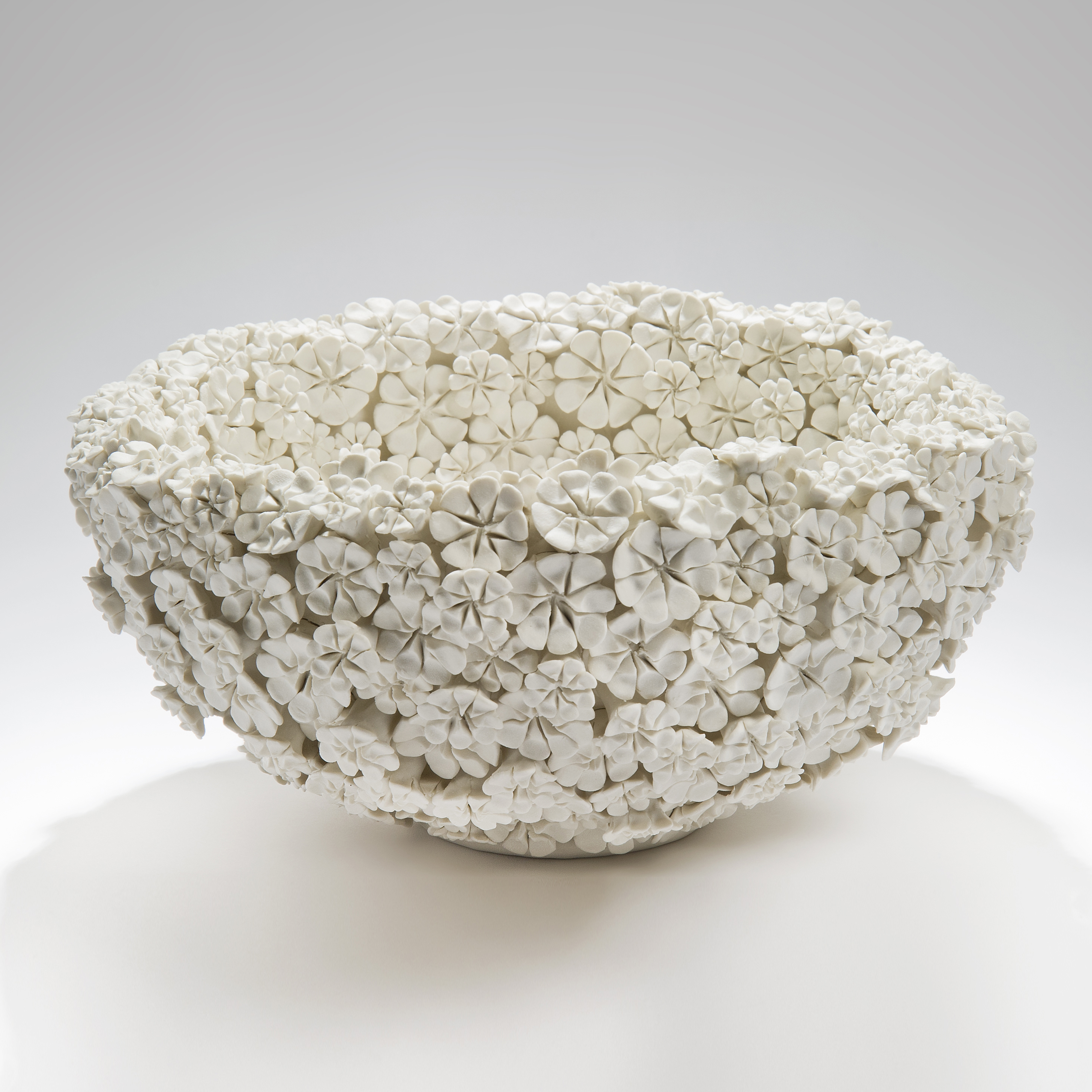 white porcelain bowl sculpture in the shape of many small daisies in white