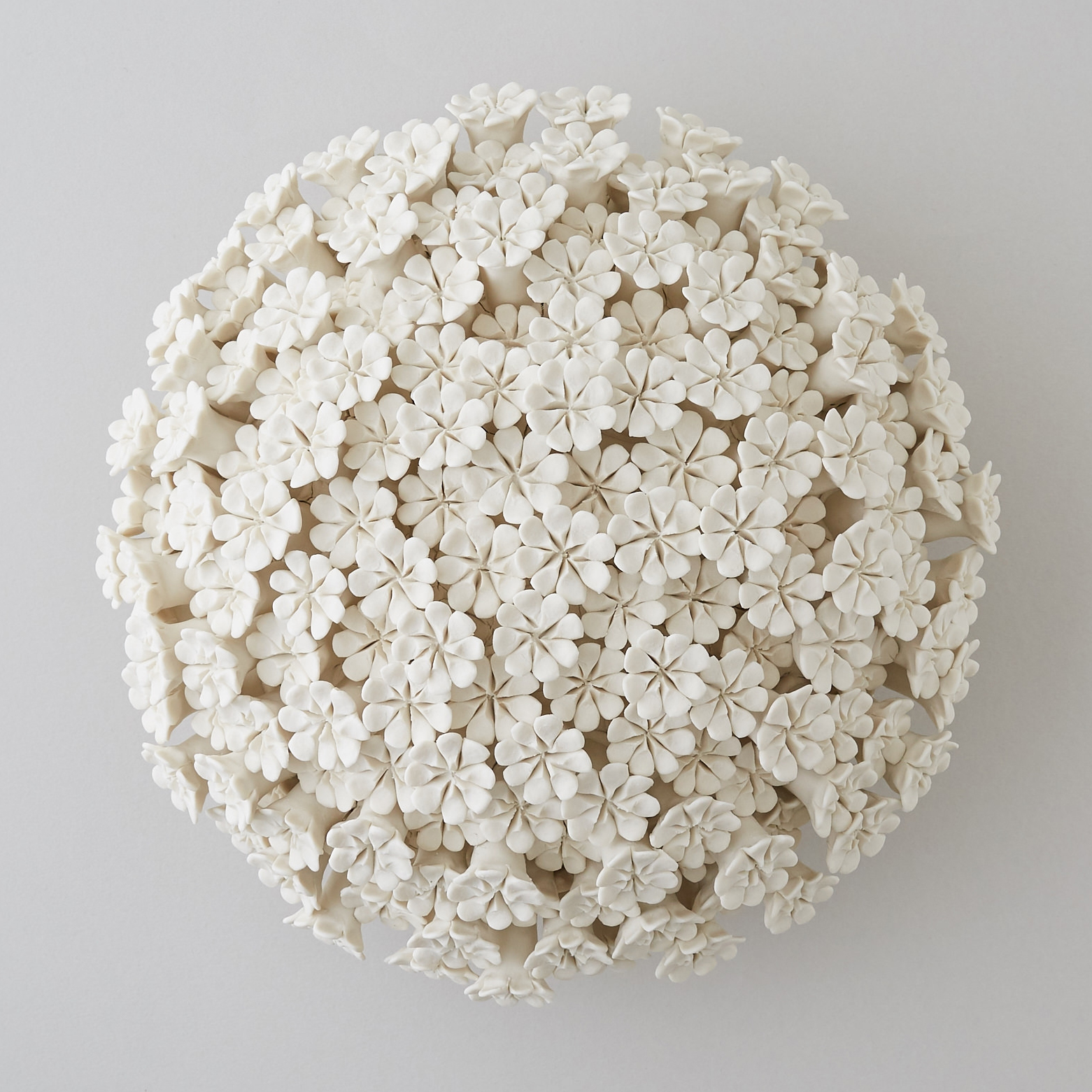 white porcelain sculpture of daisies arranged in sphere