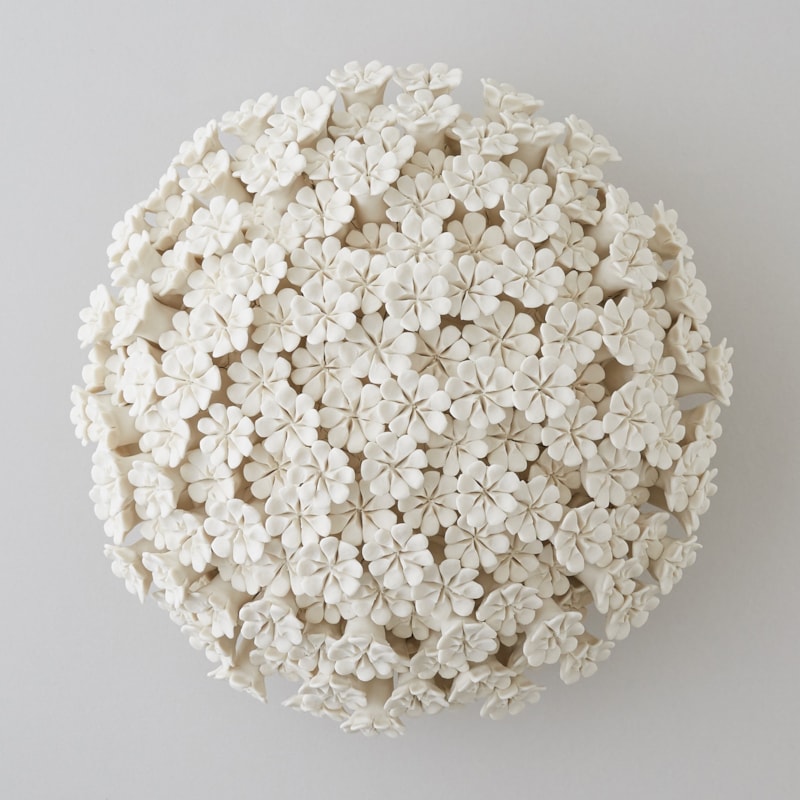 white porcelain sculpture of daisies arranged in sphere