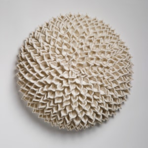 wall hanging geometric looking ceramic artwork of flowers in white