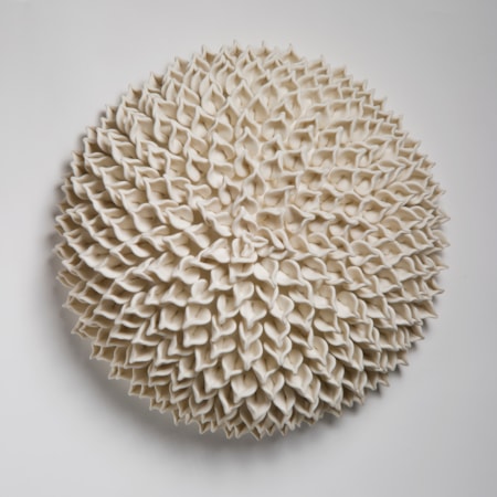 wall hanging geometric looking ceramic artwork of flowers in white