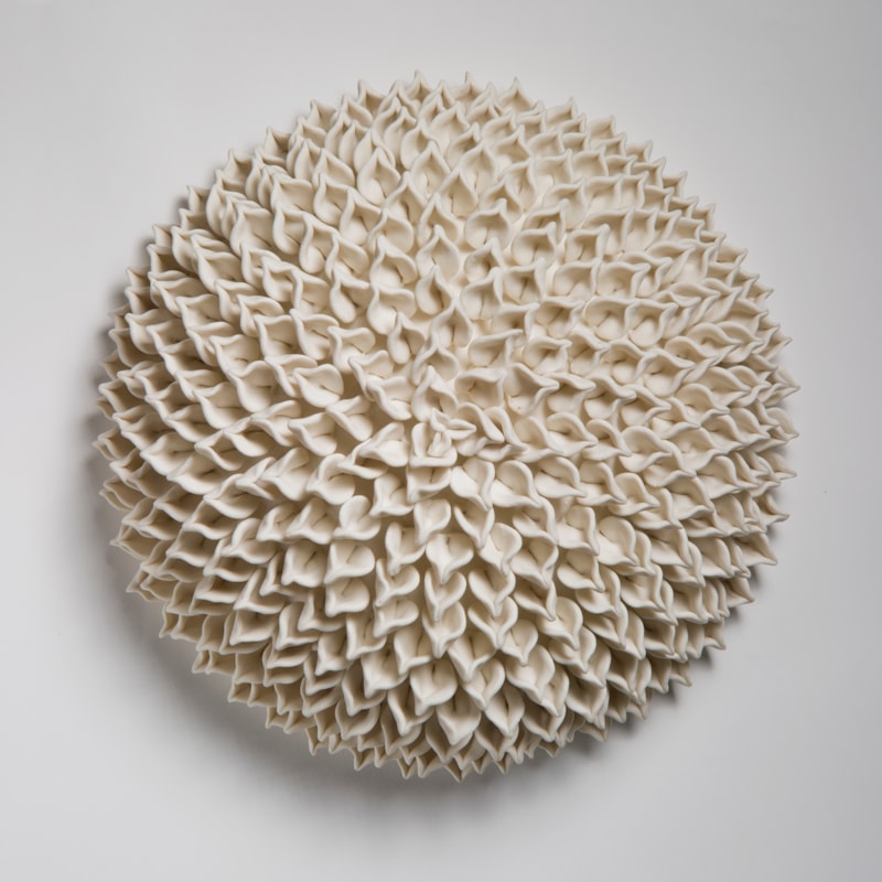 wall hanging geometric looking ceramic artwork of flowers in white
