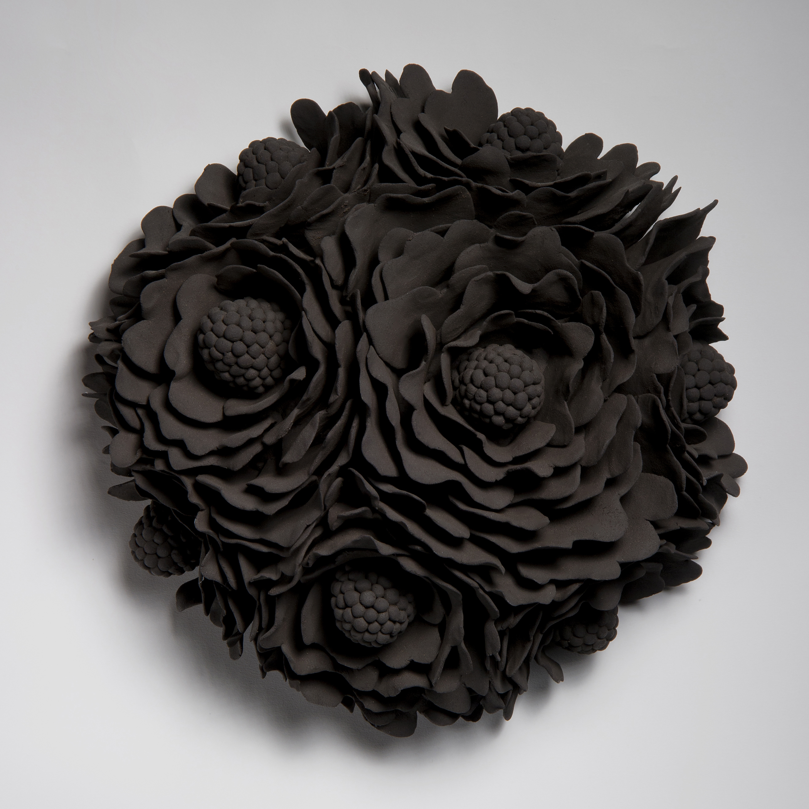 black wall hanging ceramic artwork of flowers