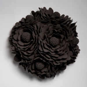 black wall hanging ceramic artwork of flowers