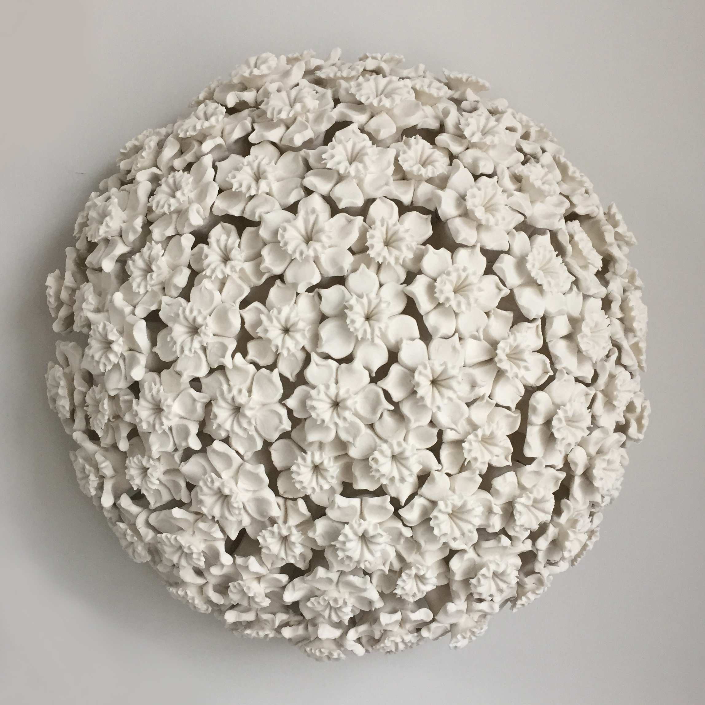 white porcelain art sculpture of daffodils arranged in sphere