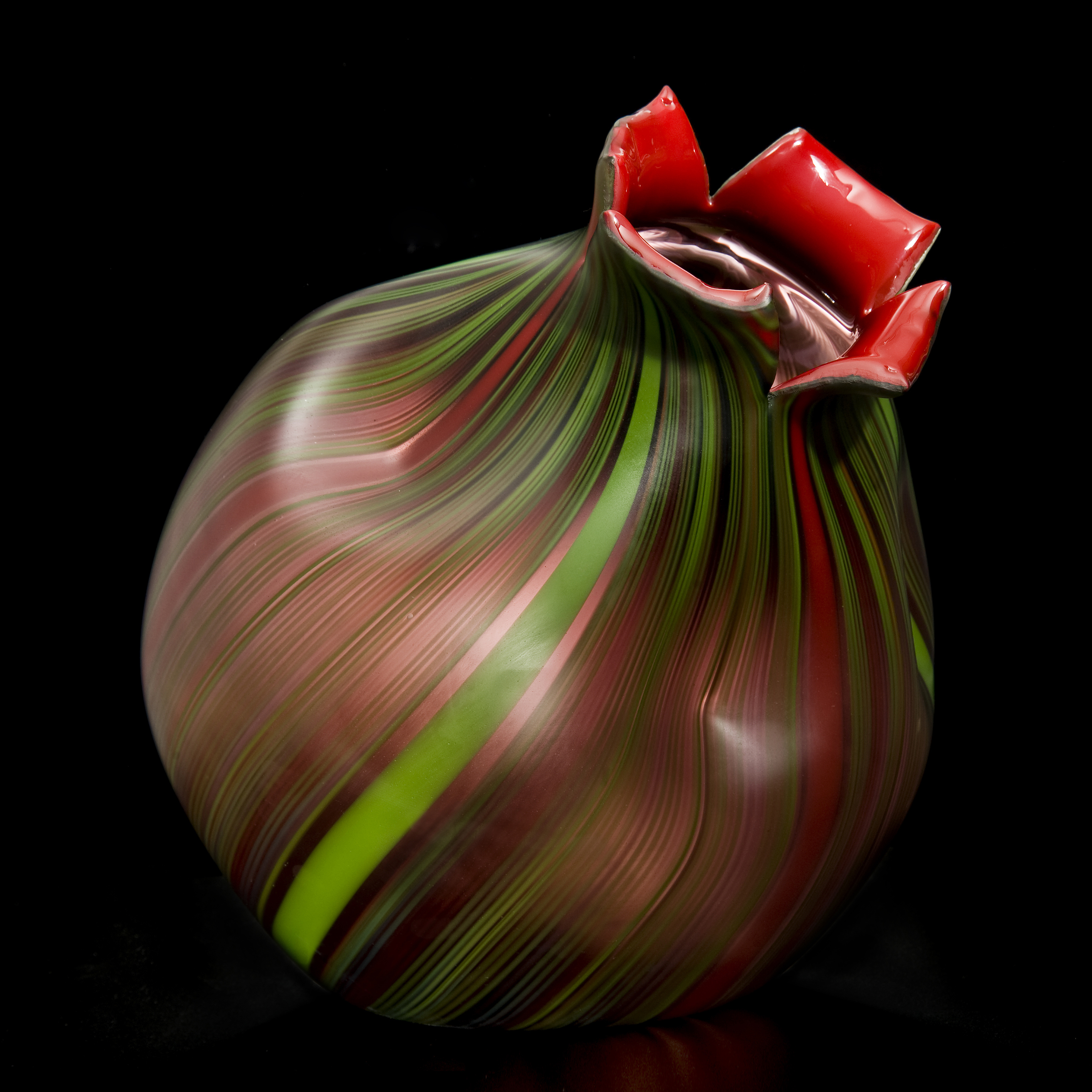 art glass sculpture resembling a nut in dark brown with green trim and red top