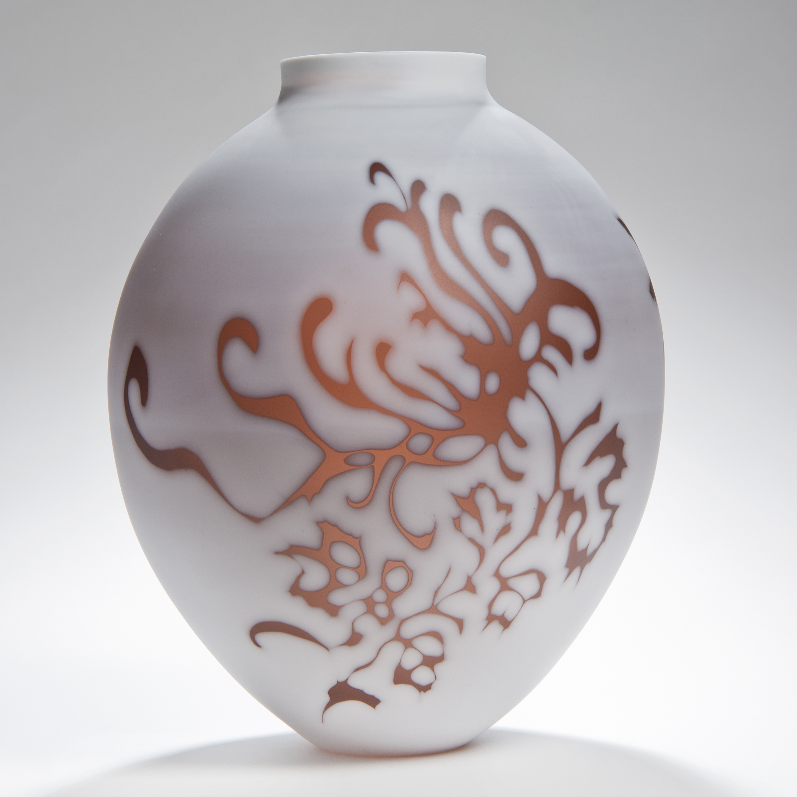 short round white cameo glass sculpture with orange floral motif