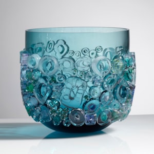 aqua blue coloured open glass vessel sculpture with busy external adornment