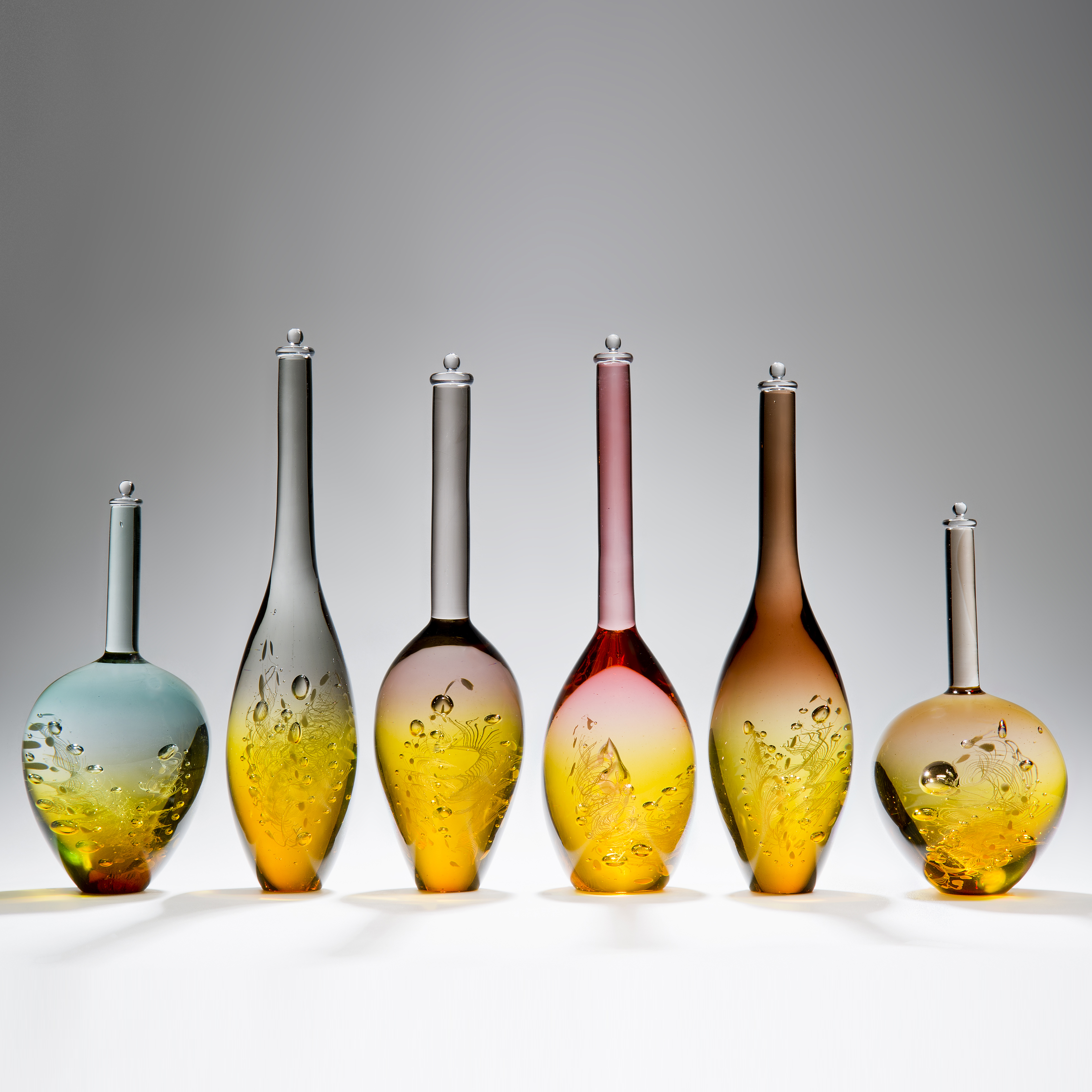 six assorted sculpted art glass bottles in amber and pastel