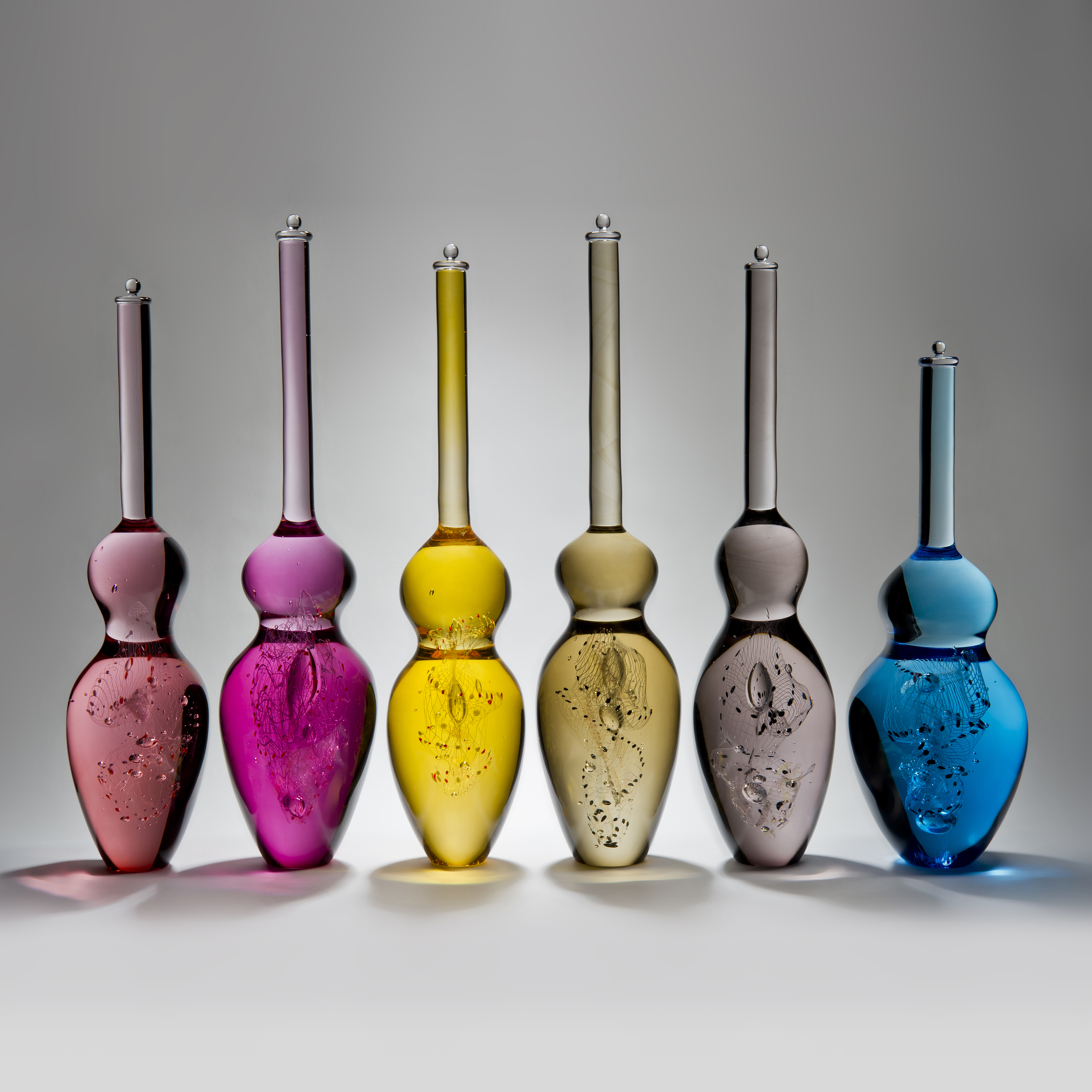 six art glass sculptures in the shape of skittles in bright modern colours