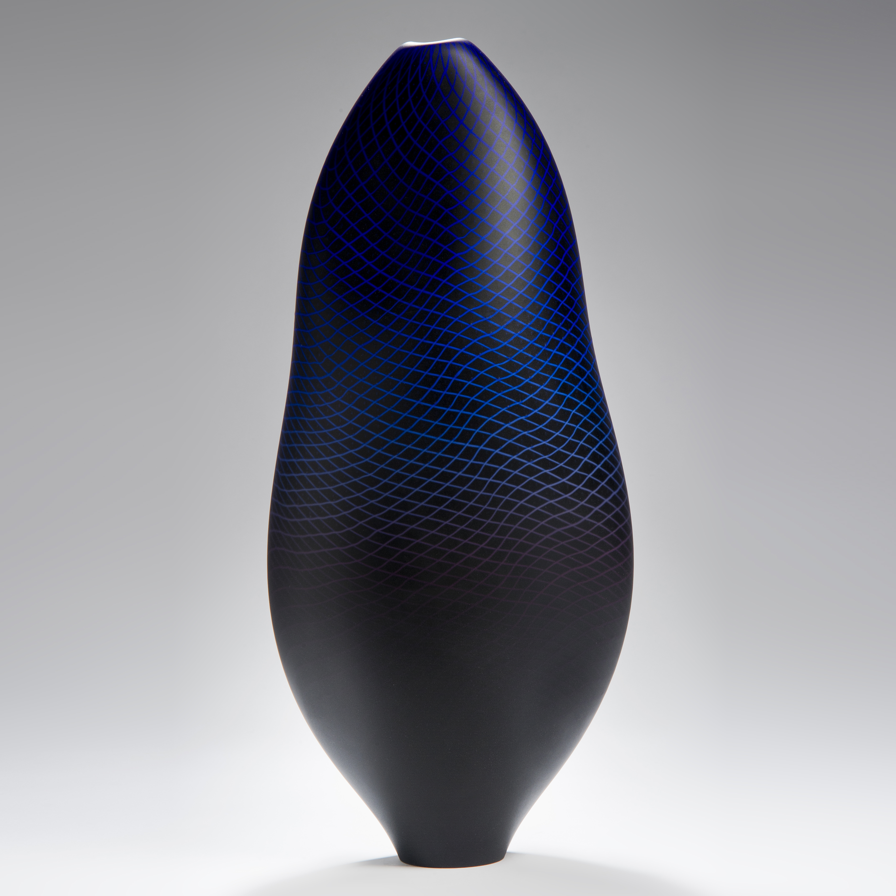 modern art glass sculptured vessel in dark blue with external geometric engraving