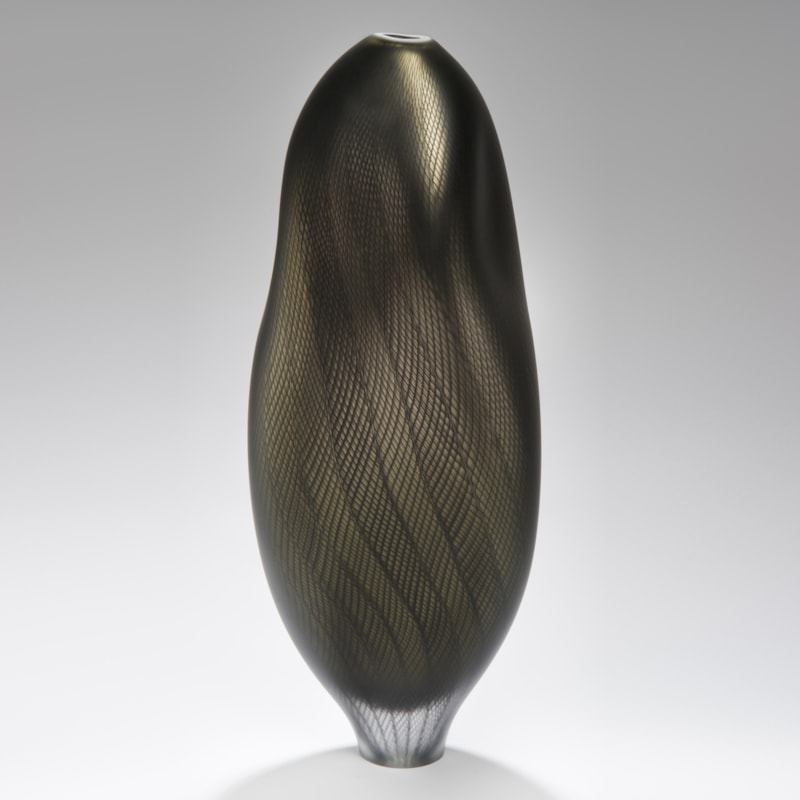 dark and light grey glass art sculpture of abstract vase shape with patterned exterior