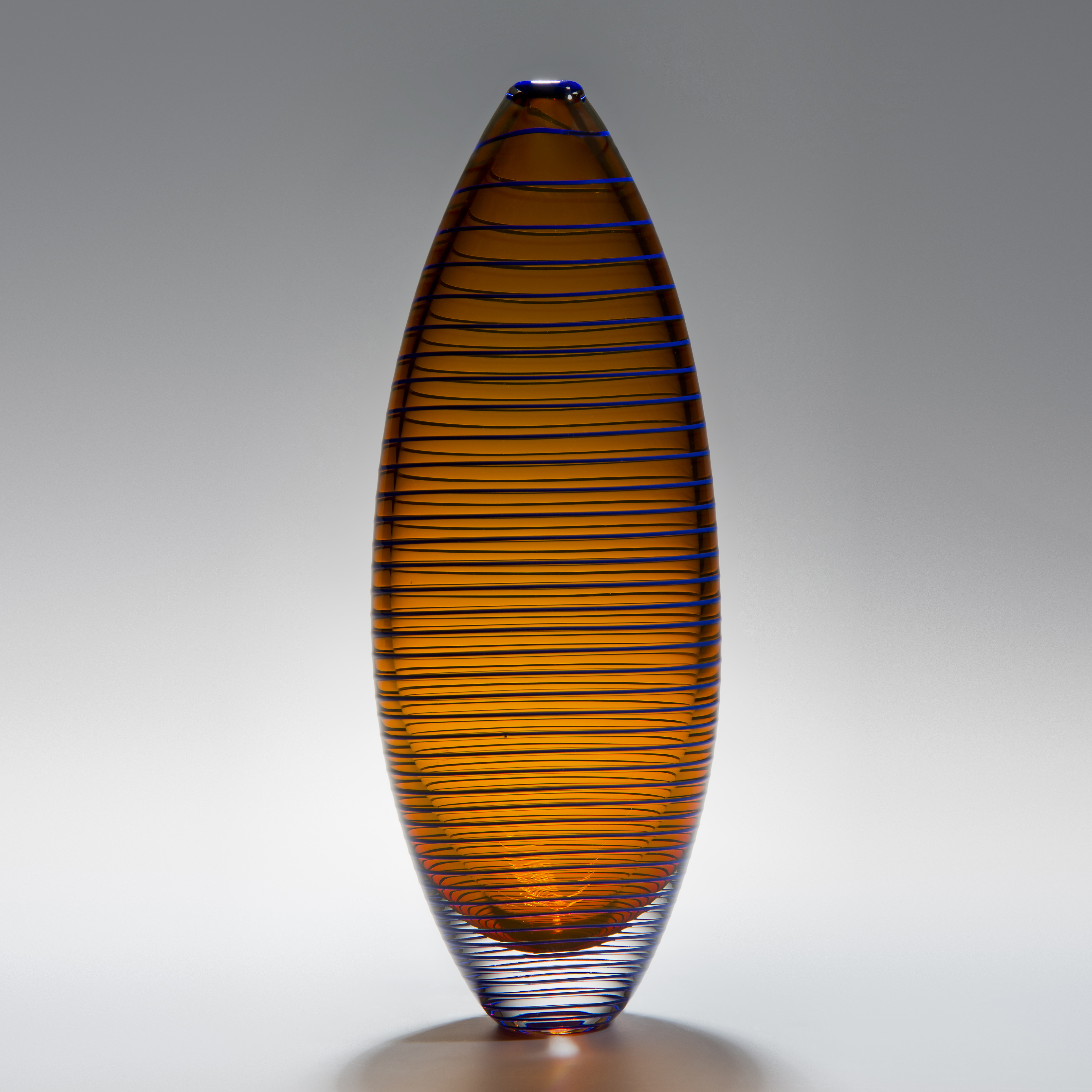 tall oval shaped amber vase sculpture with horizontal black lines