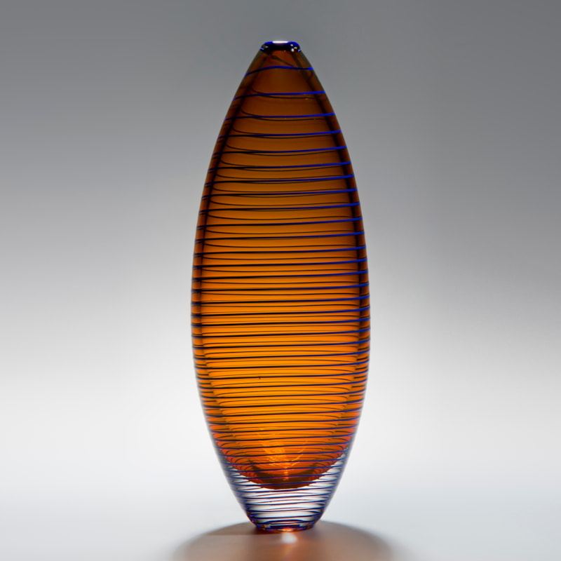 tall oval shaped amber vase sculpture with horizontal black lines