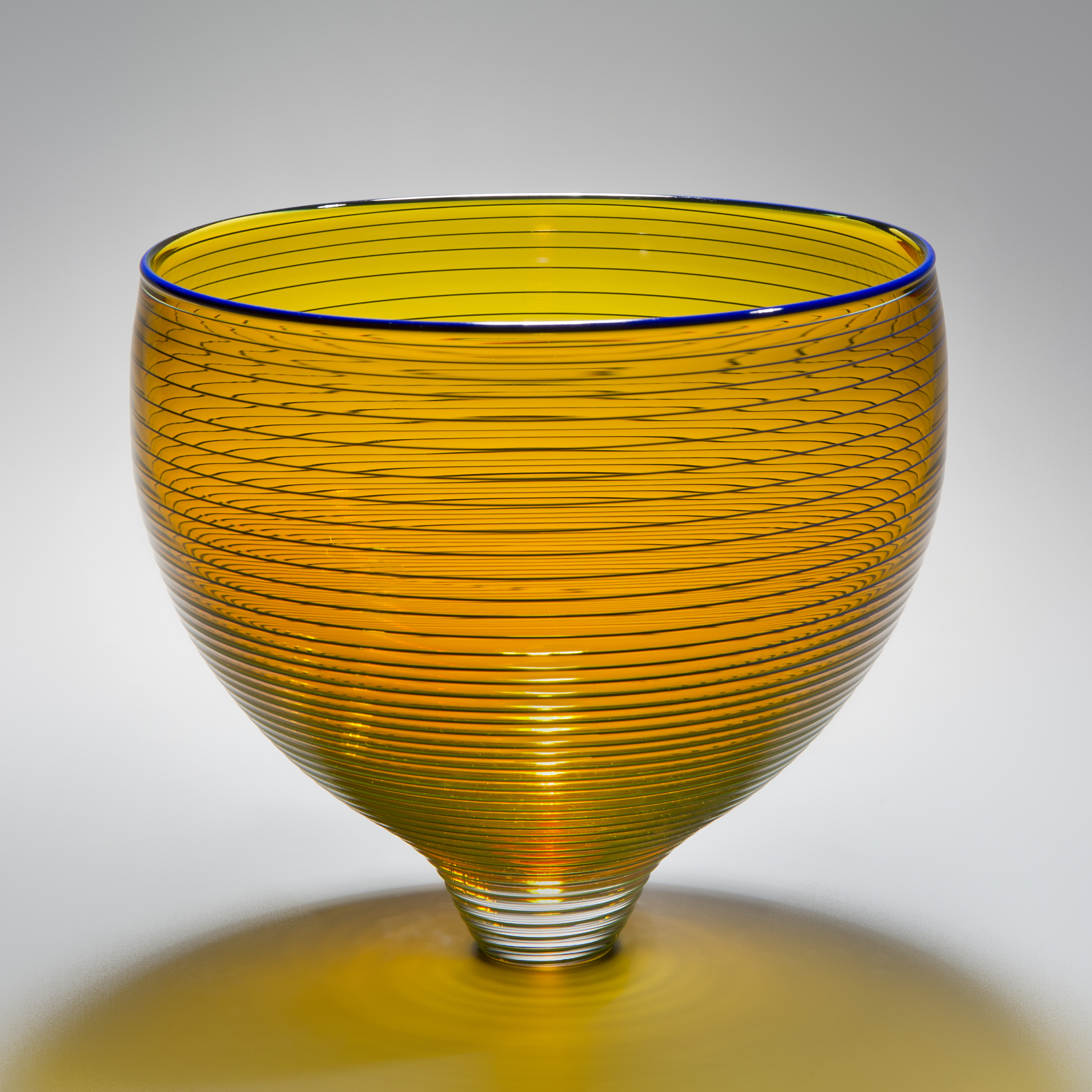 gold art glass bowl with thin black horizontal lines