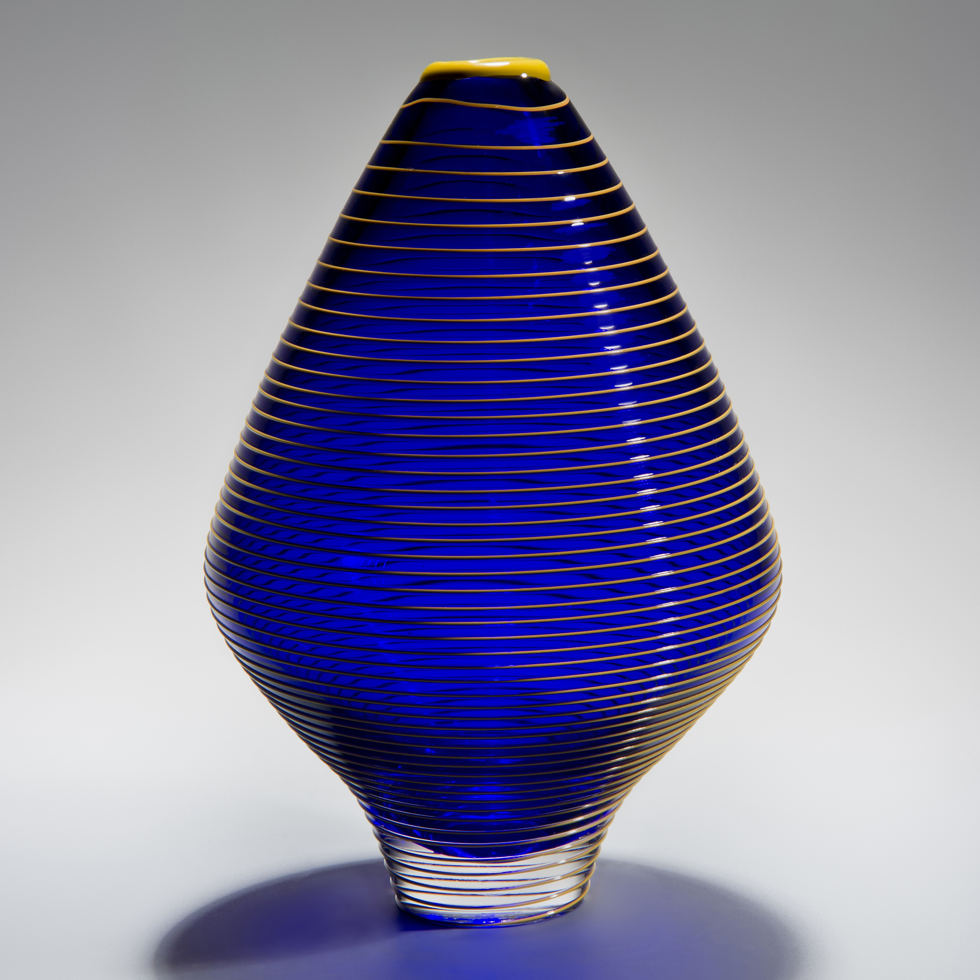 minimalist short electric blue glass  vase sculpture with faint yellow horizontal line pattern