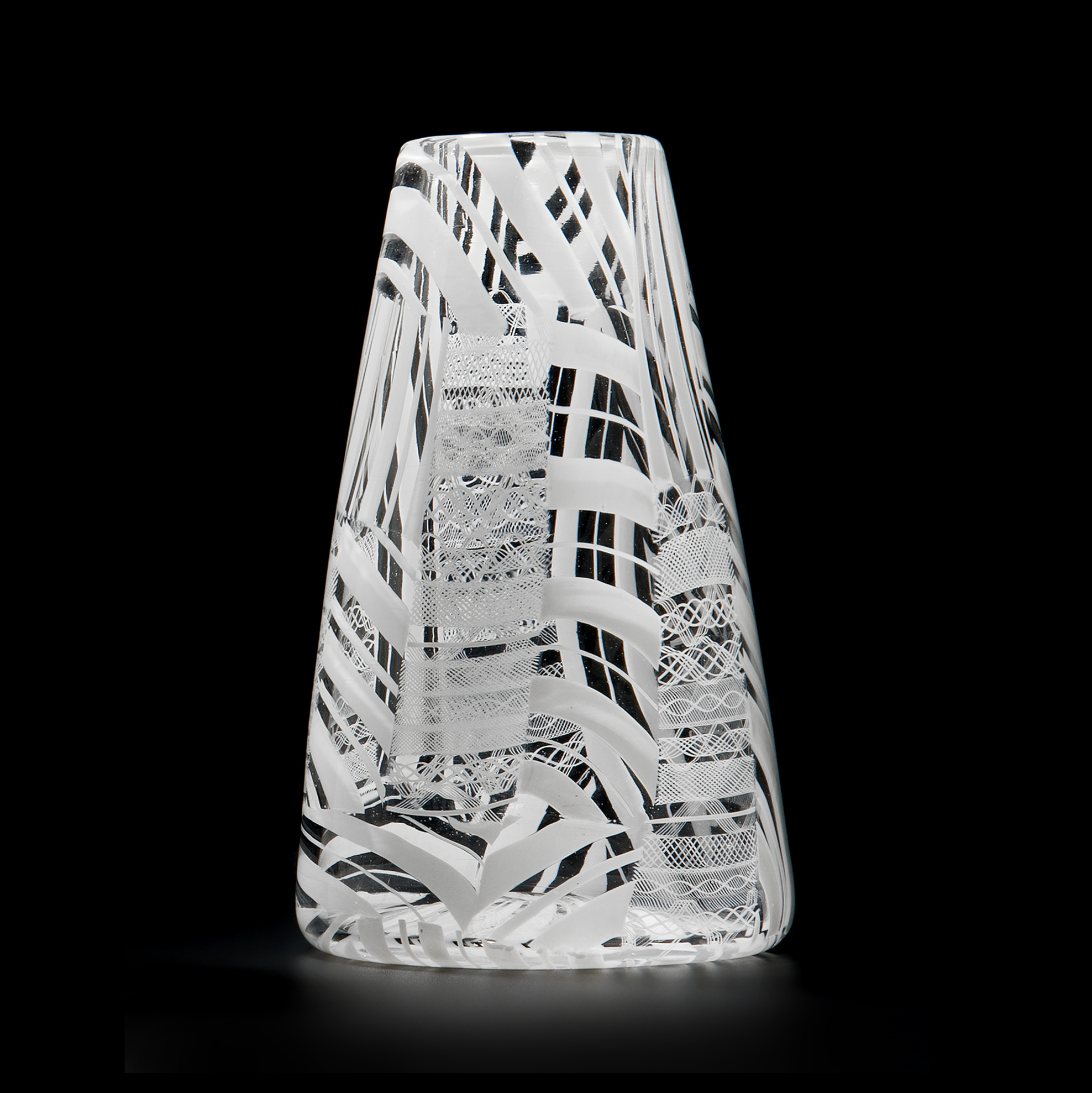 clear glass sculpted vessel with white patterned exterior