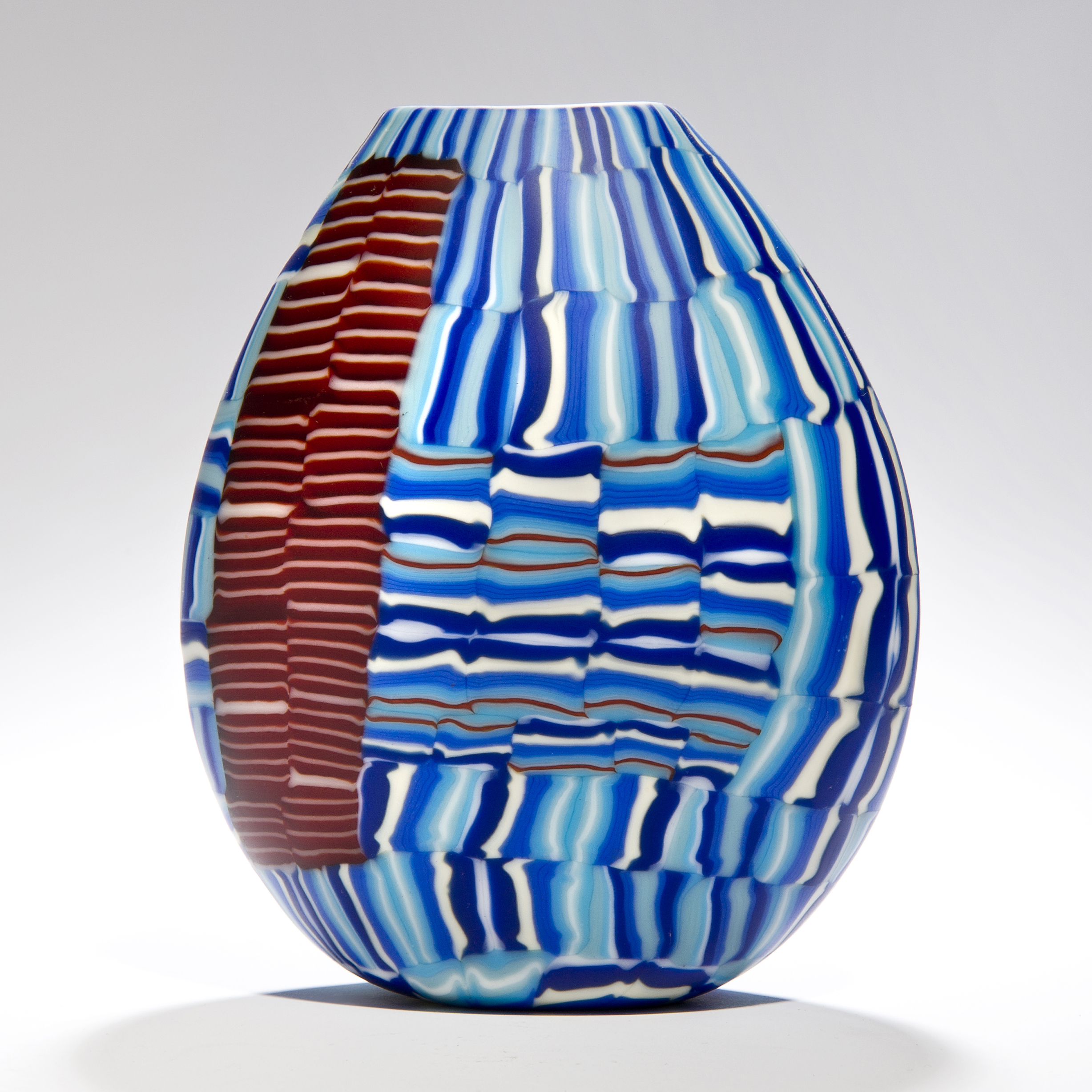 glass art vessel sculpture with blue and terracotta line patterns