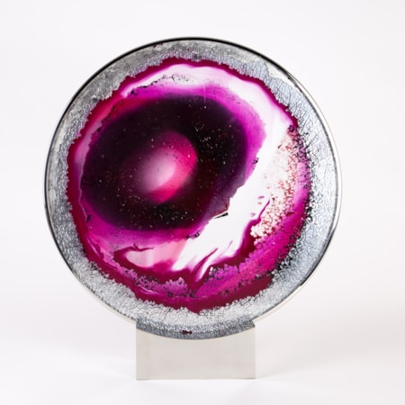pink, purple and white round glass sculpture with eye like shape on bezel and stand