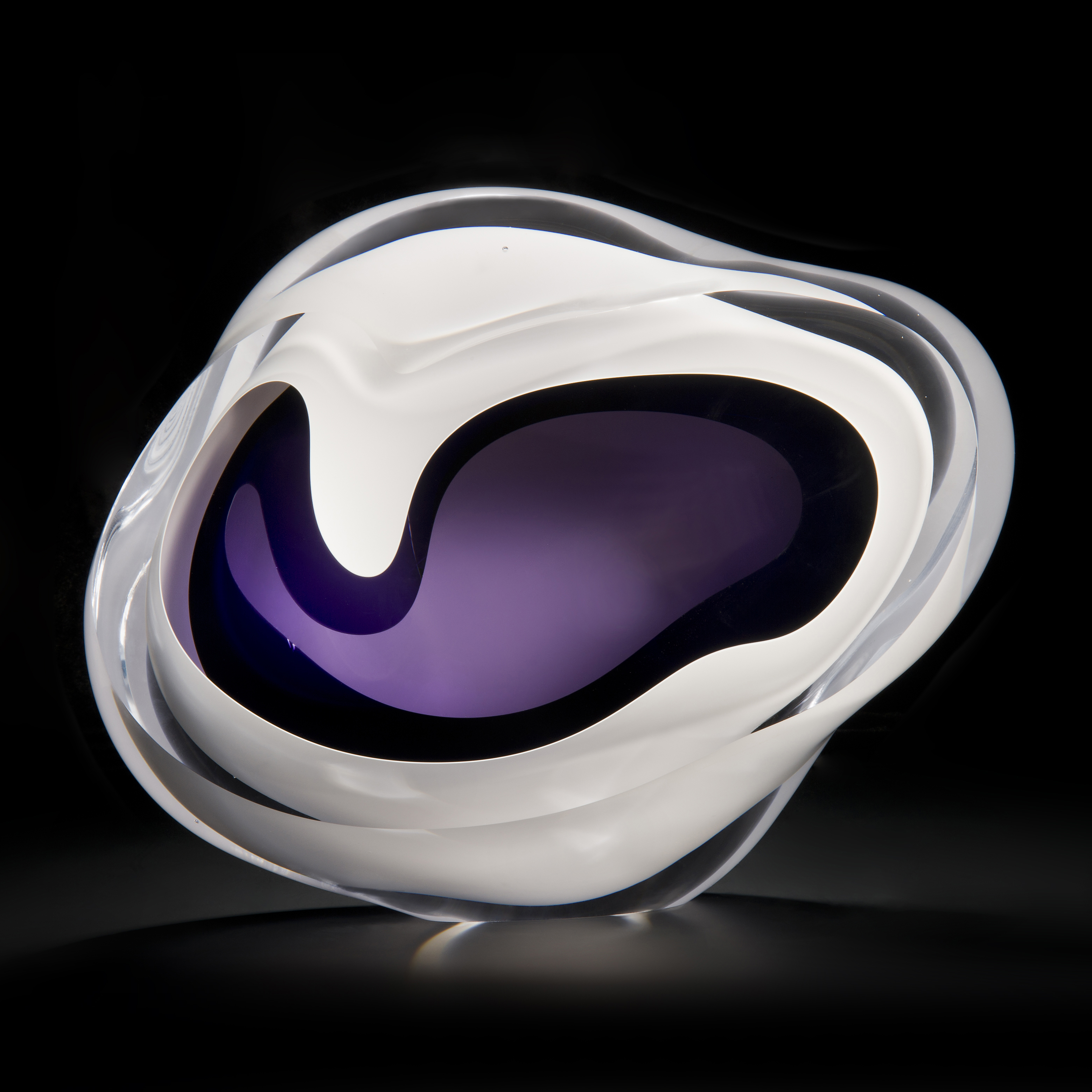 minimalist art glass sculpture of a rock in white with purple and black centre
