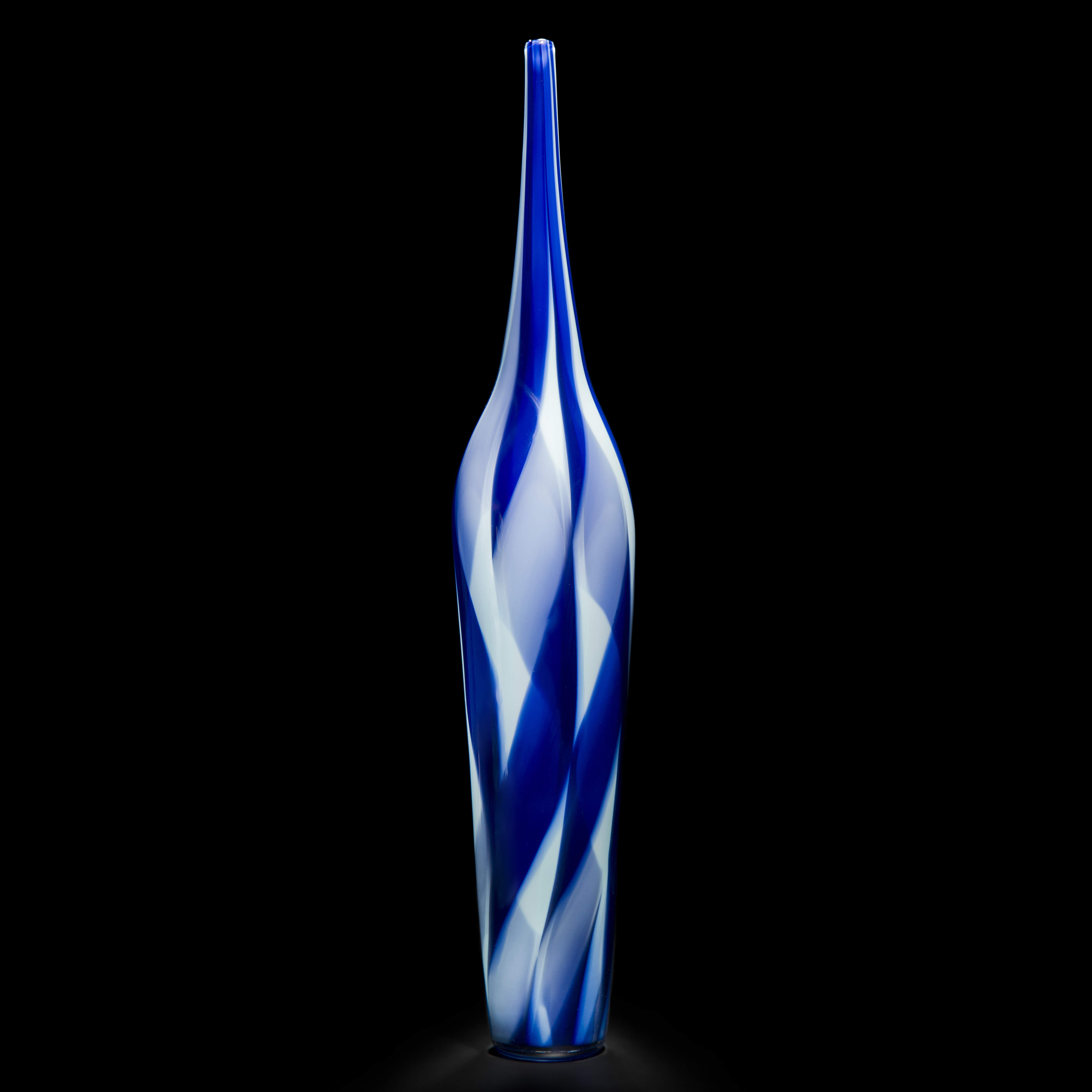 tall and thin bottle shaped decorative glass sculpture in shades of blue and white with thin neck
