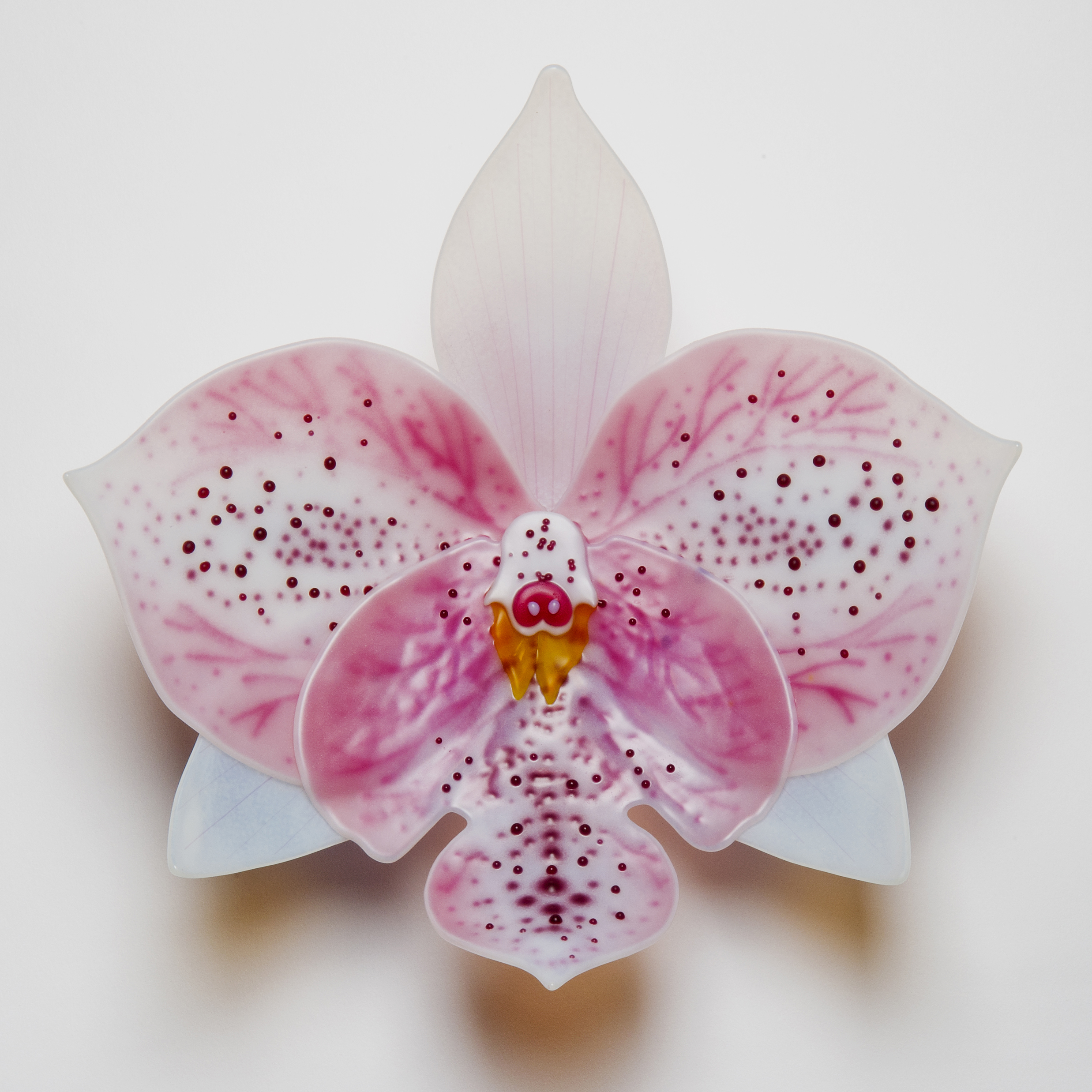 sculpted glass art of an exotic orchid in white and pink