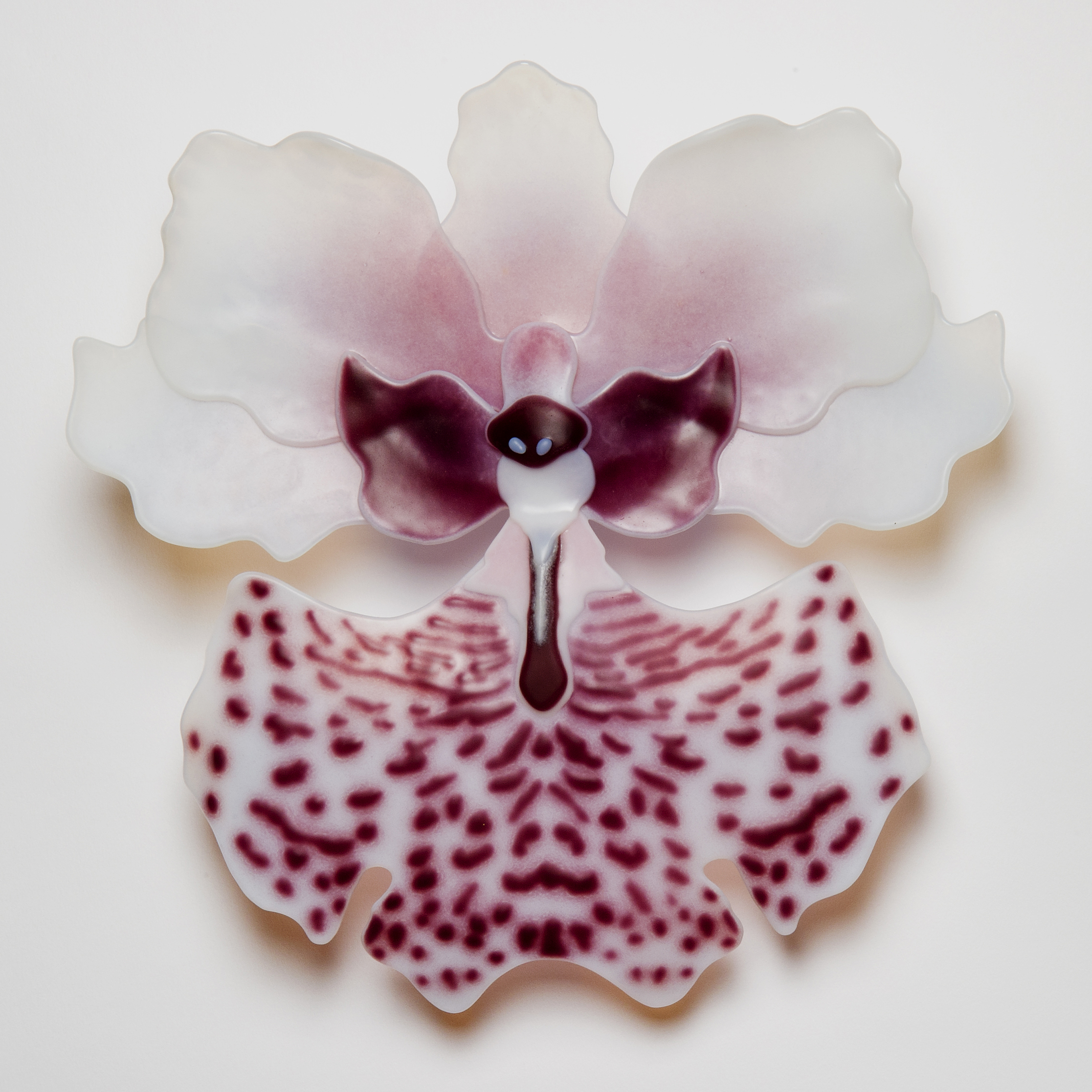 sculpted glass art of exotic flower in white with pink speckles and purple detail