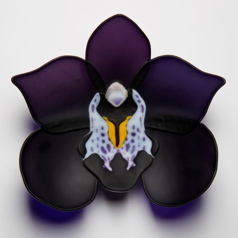 sculpted glass artwork of a black and dark purple flower with lighter detail in centre