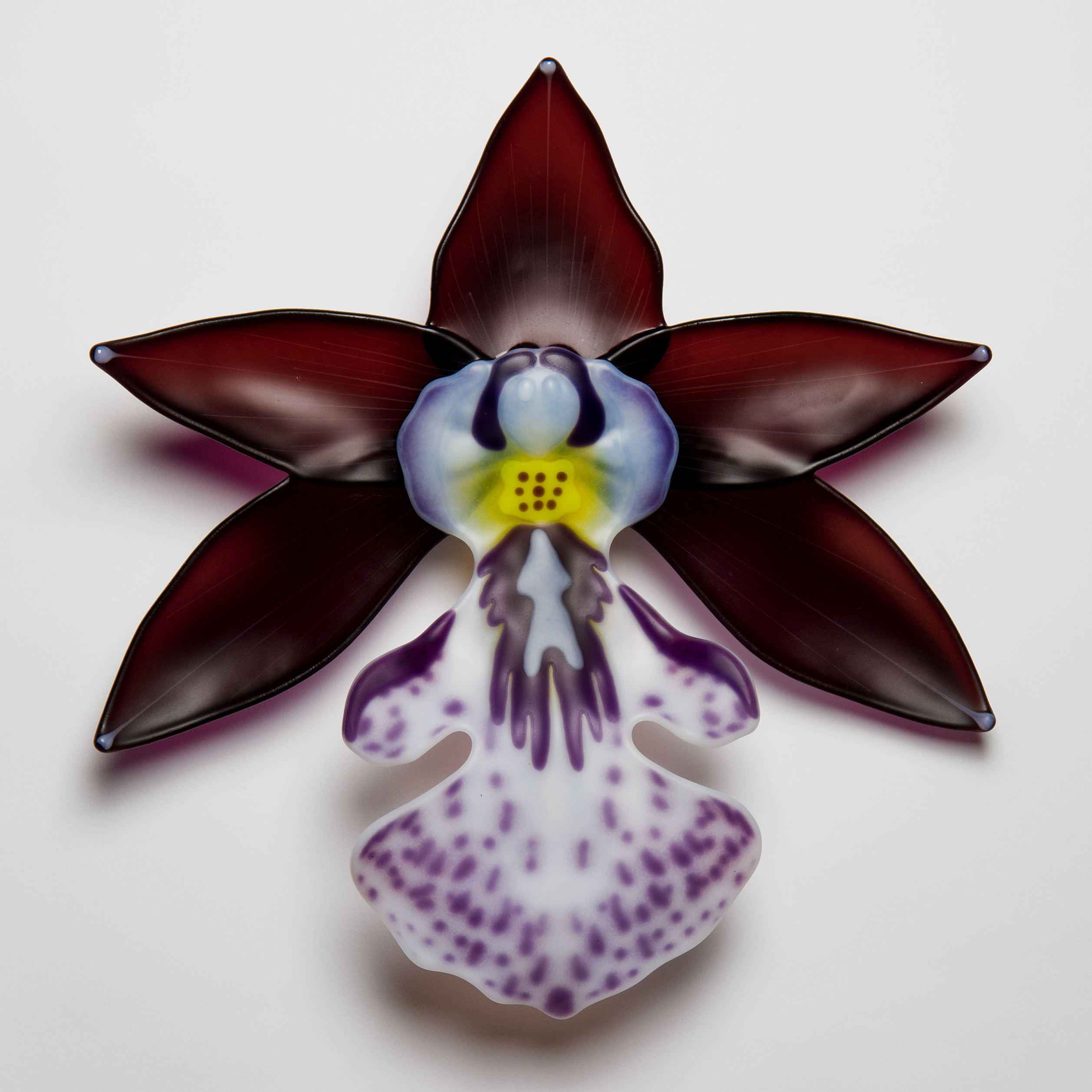 glass sculpture of exotic flower in burgandy white and purple speckles