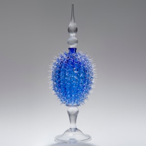 glass sculpture of spiked blue ball in the centre of clear glass base and top
